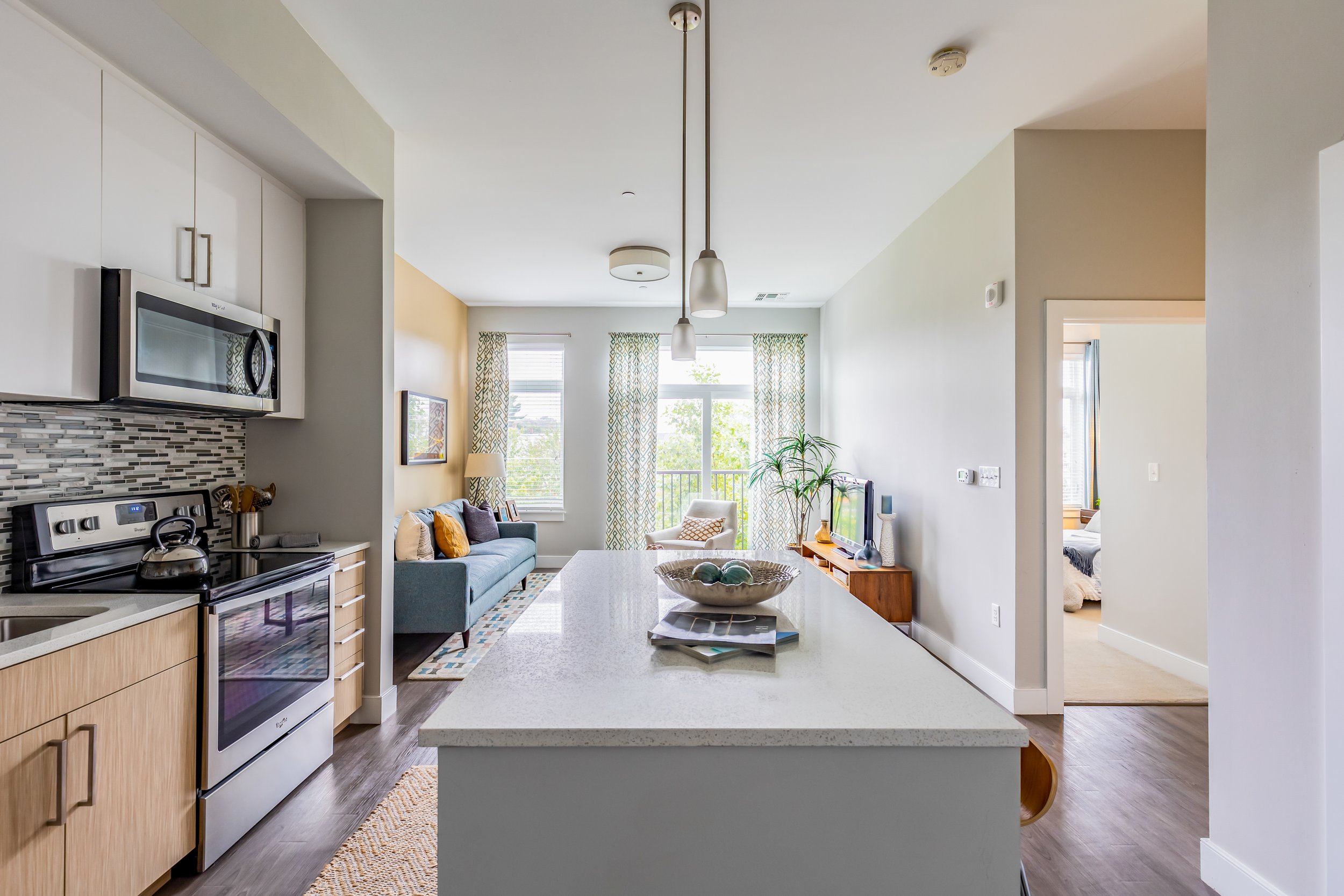 Open-concept kitchen leading into living area and hallway, showing natural flow between interior spaces in a real estate listing