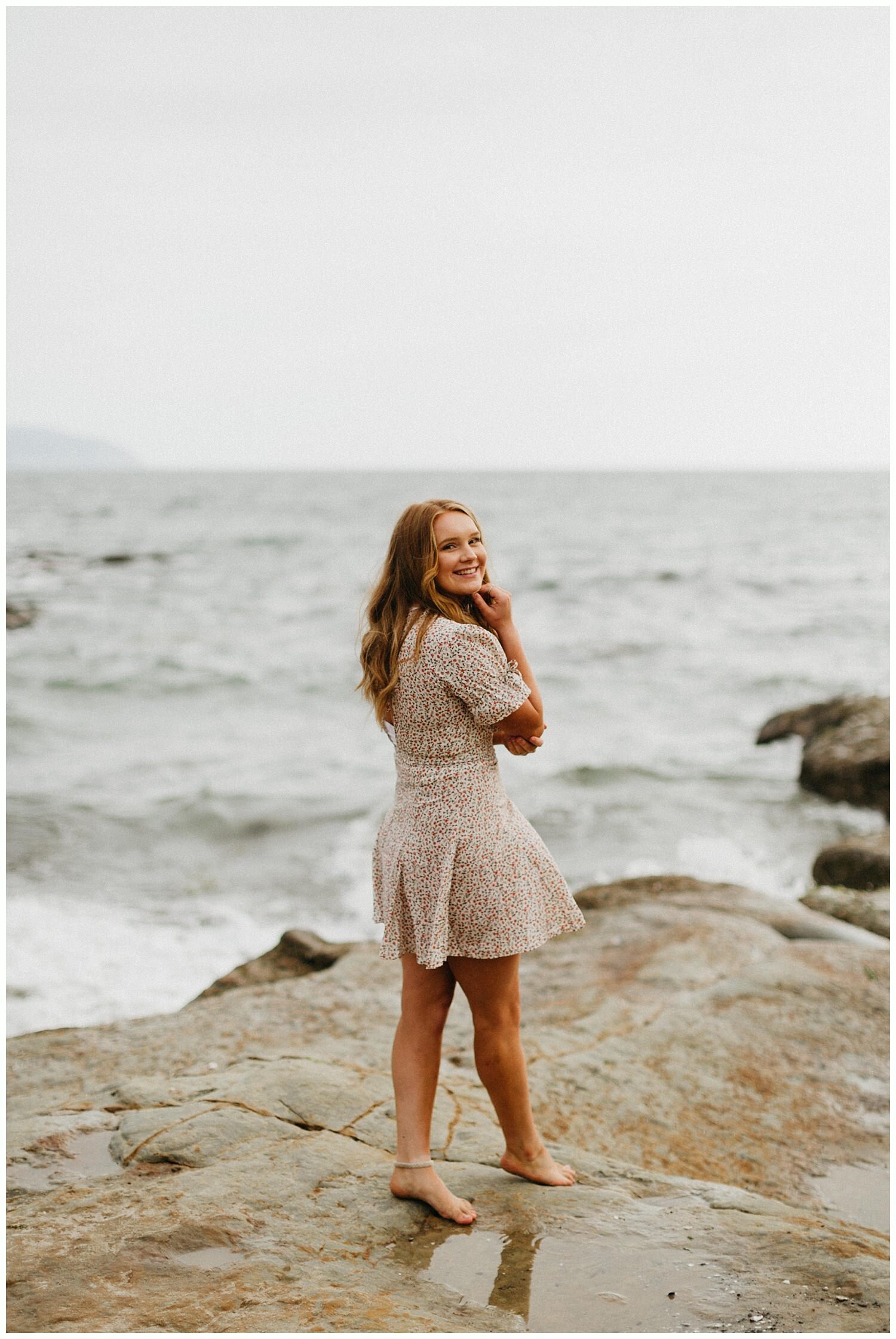  Red head girl wearing a dress at the beach for her senior portraits in Oregon. 