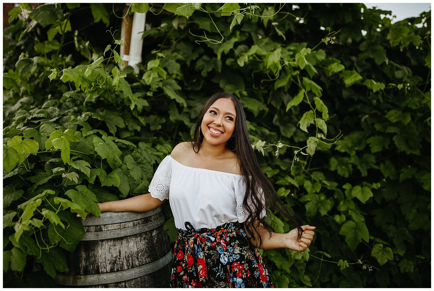  High school girl standing in front of green bush in Portland, Oregon. 