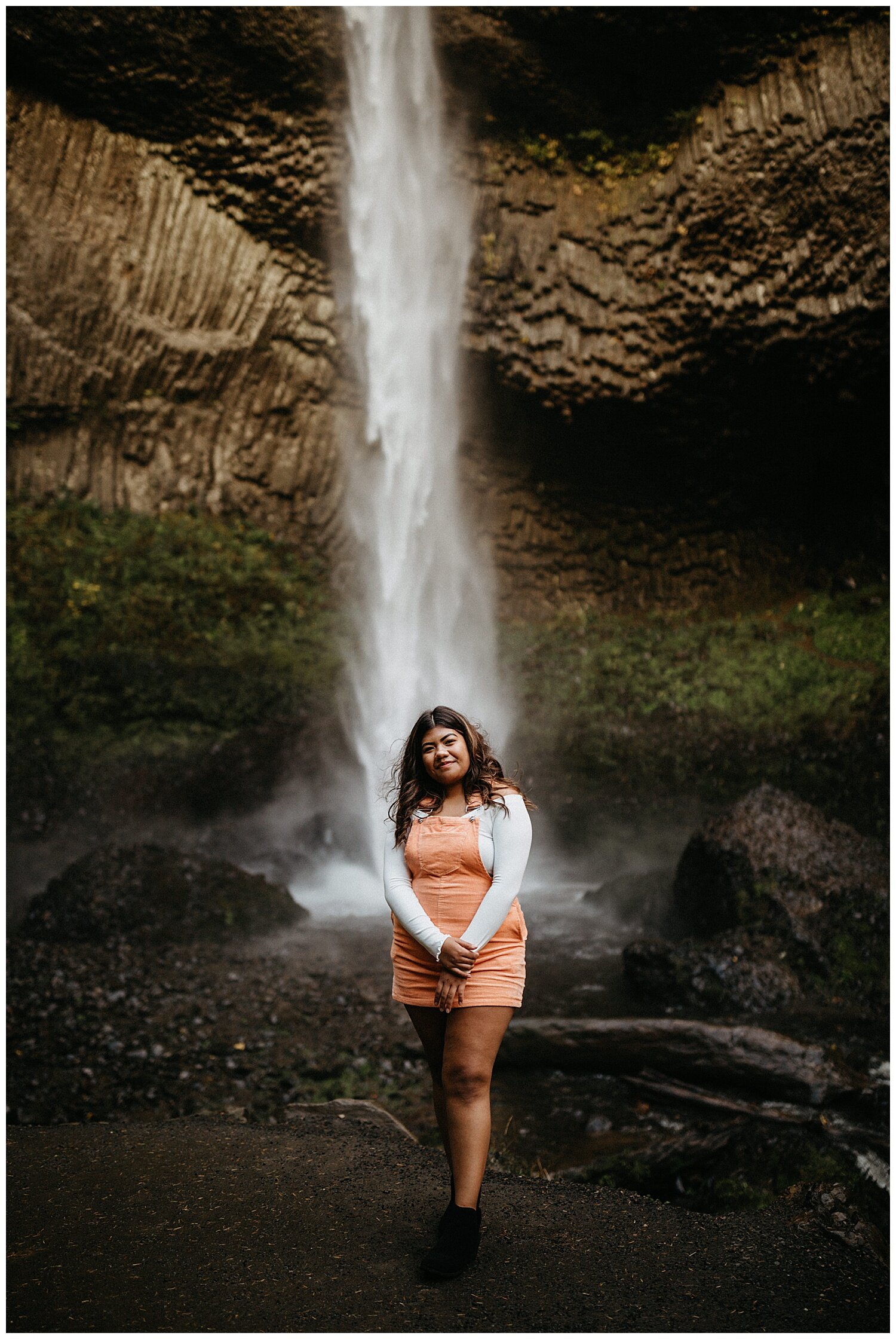  High school senior standing in front of waterfall for her portraits. 