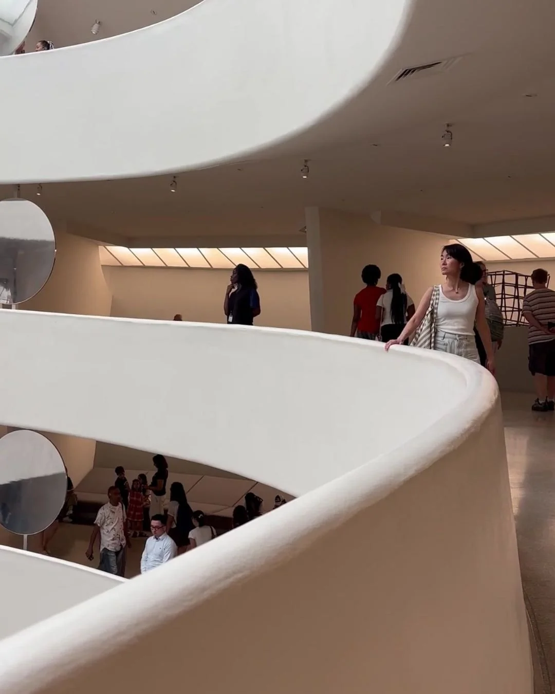 Interior of the Guggenheim Museum in New York, showing the curved white architecture and sweeping gallery walkways.
