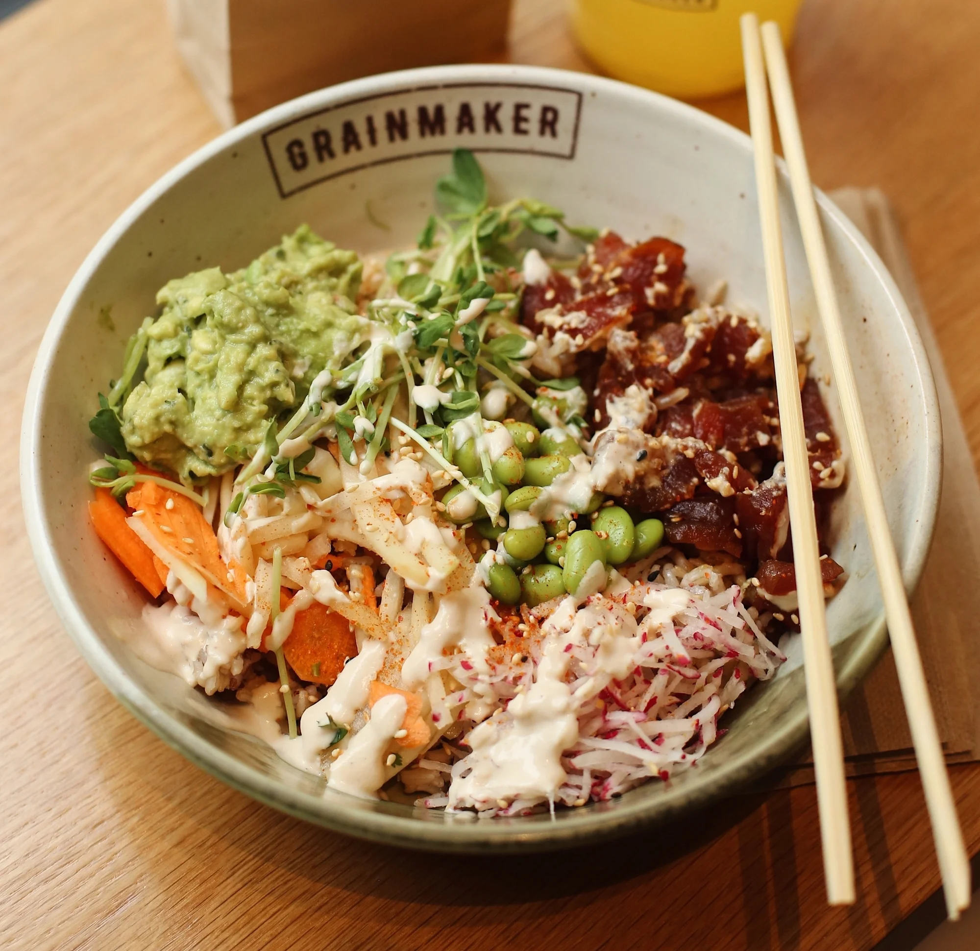 Ahi Tuna Poke ($14.50) - Volcano brown rice, yellowfin ahi tuna in a poke vinagrette, papaya / carrot mix, edamame, Thai guacamole, radish, spicy mayo, snow pea shoot, sesame seeds, chili-pepper flakes.