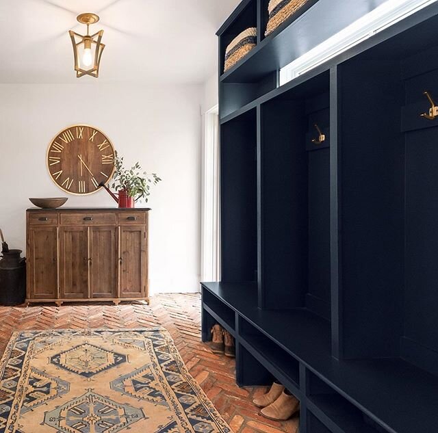 Living in New England we all need a mudroom like this! My client wanted a spot for boots, shoes, jackets + baskets up top for gloves &amp; hats! Love how the rich navy pairs with the orangey/red reclaimed bricks! #reclaimedbricks #navycabinets #mudro