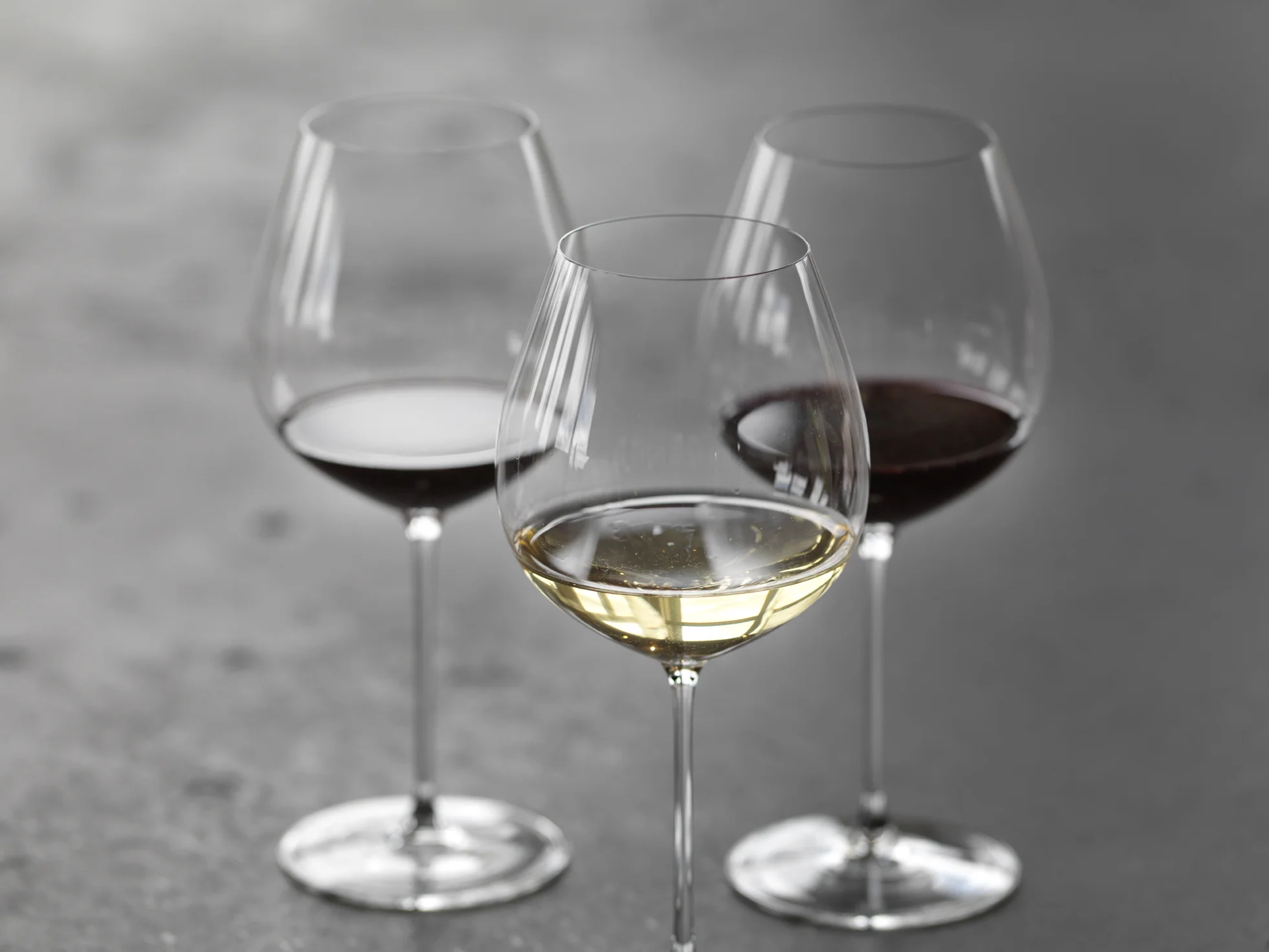 Trio of wine glasses set on iron table