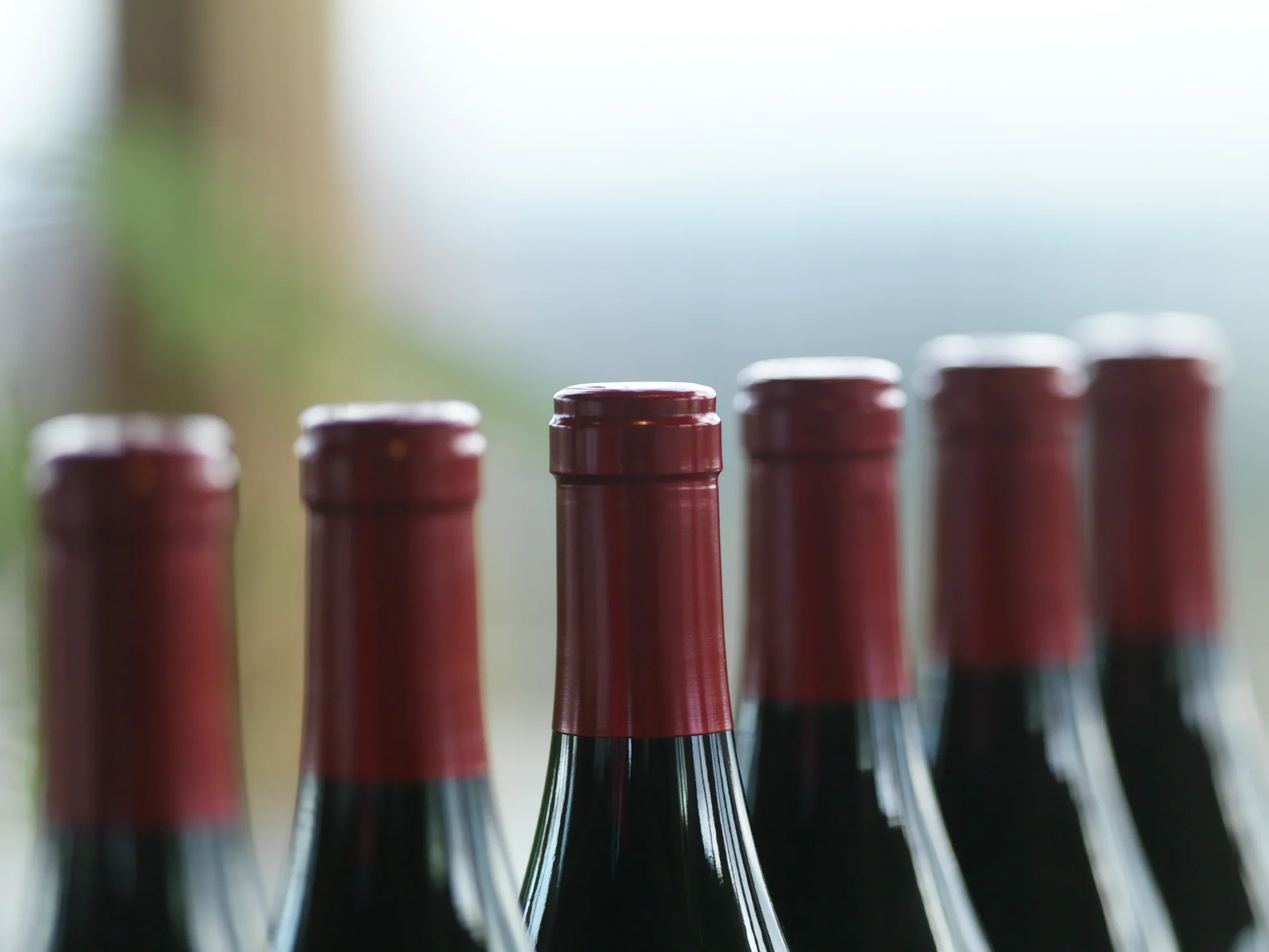 Row of bottle necks and their deep red foil