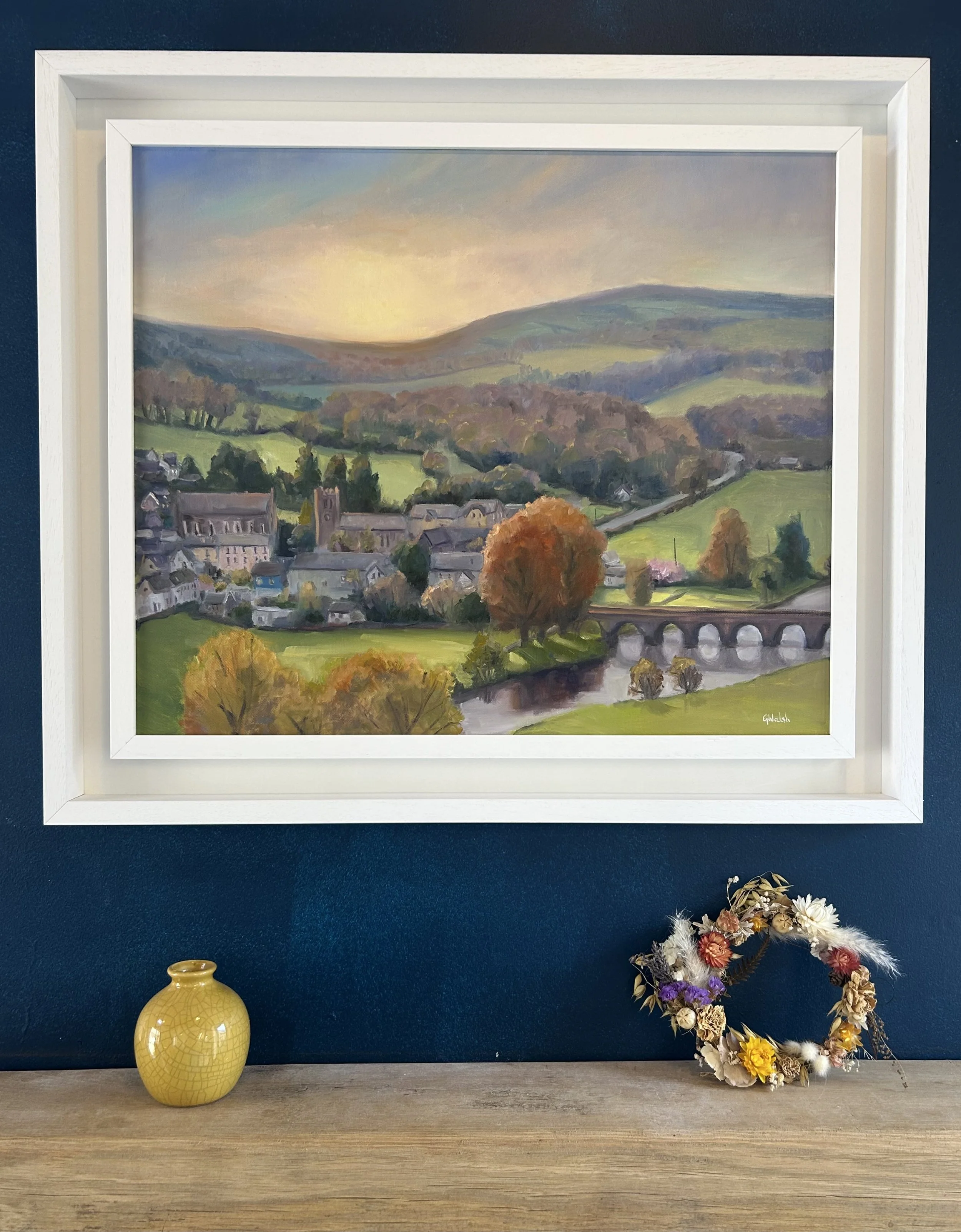 Oil painting of the historic village of Inistioge, Kilkenny, showing traditional stone buildings and lush greenery.