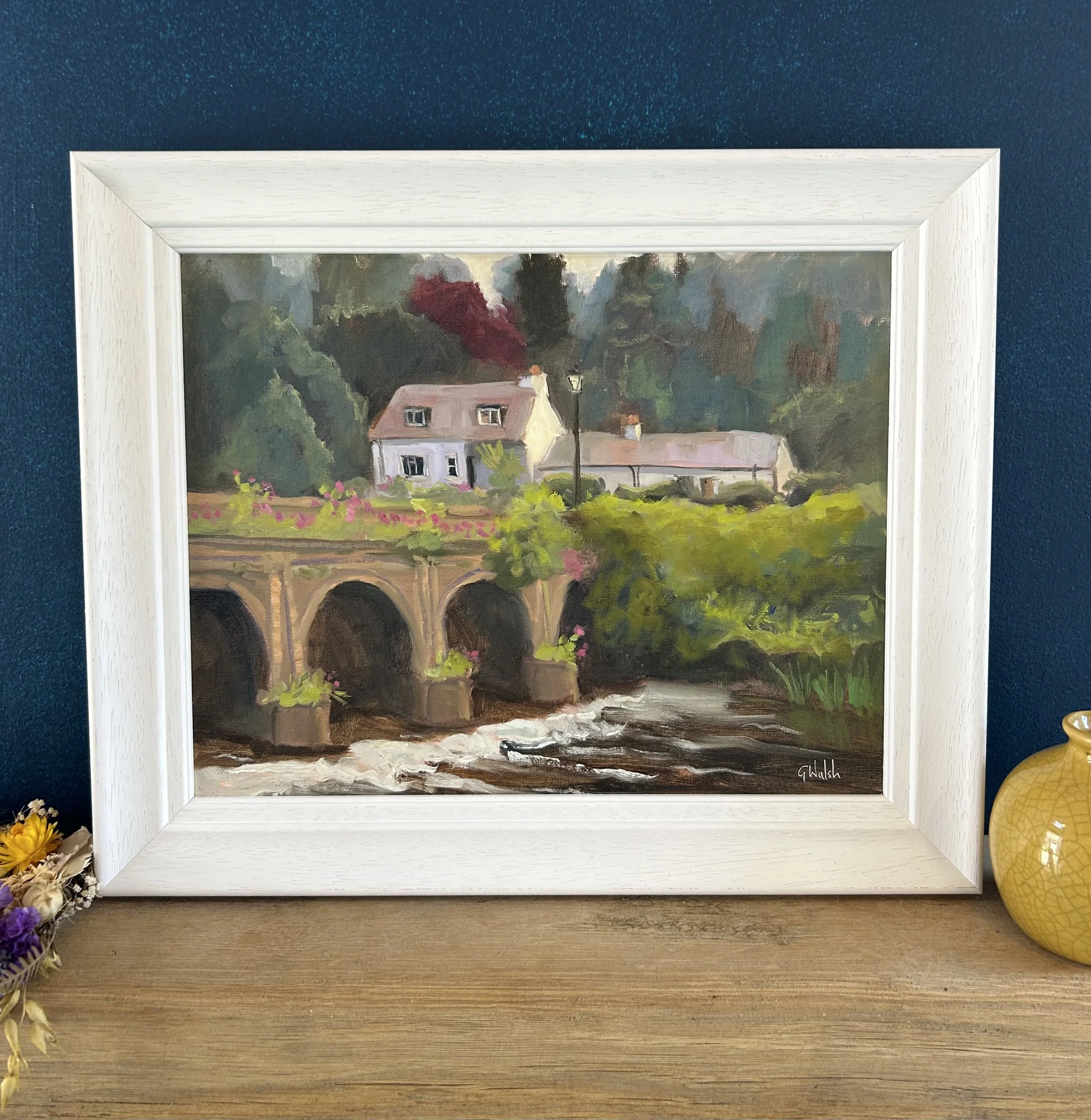 Painting of the famous 18th-century stone bridge in Inistioge, Kilkenny, spanning the River Nore with reflections in the water.