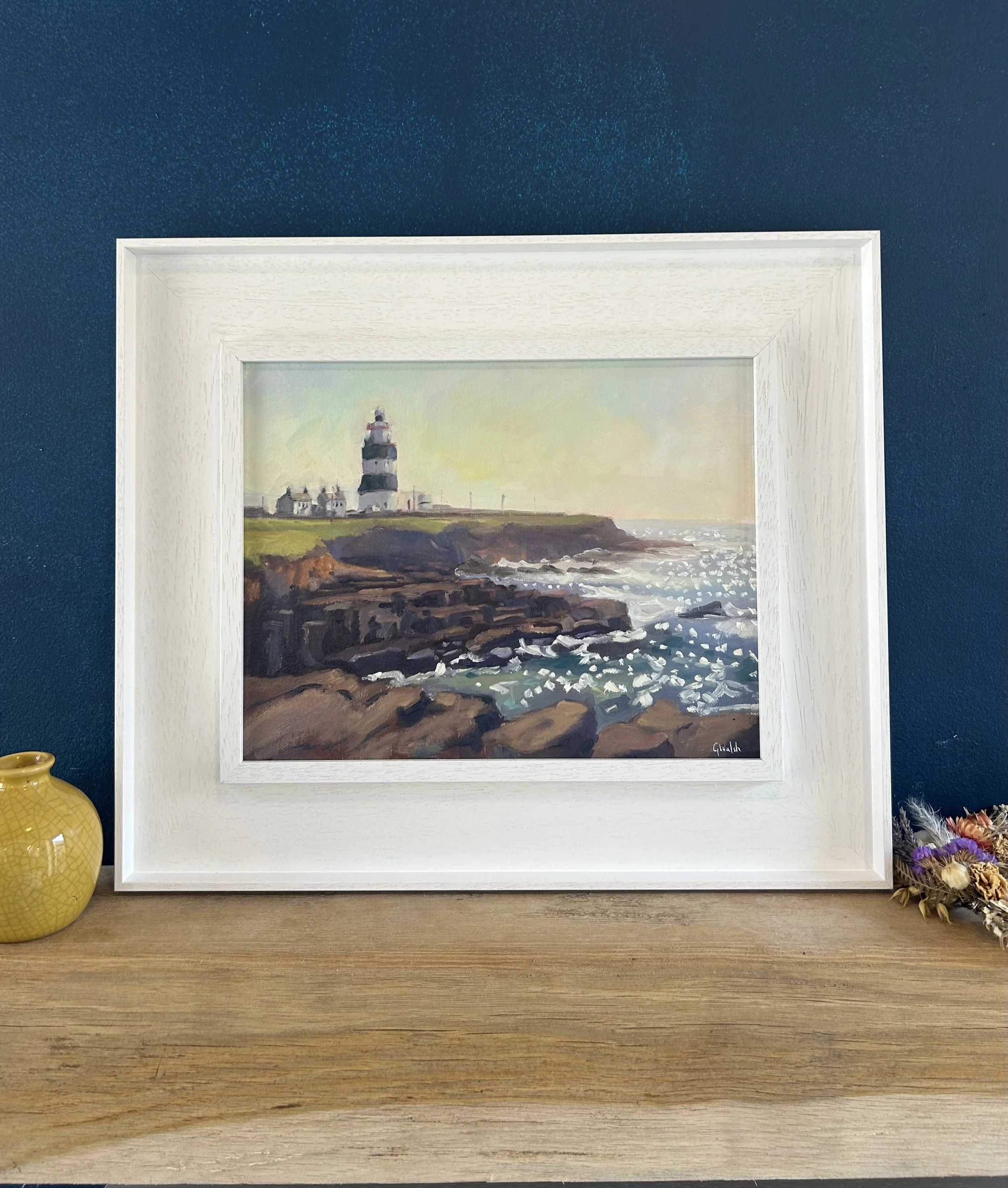 Oil painting of the historic Hook Head Lighthouse in Wexford, Ireland, seen from a distance across the coastal landscape.