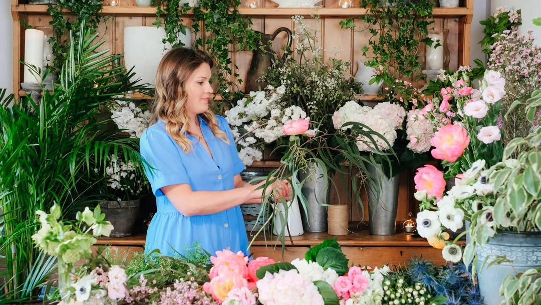 Alex arranging flowers at her studio bench