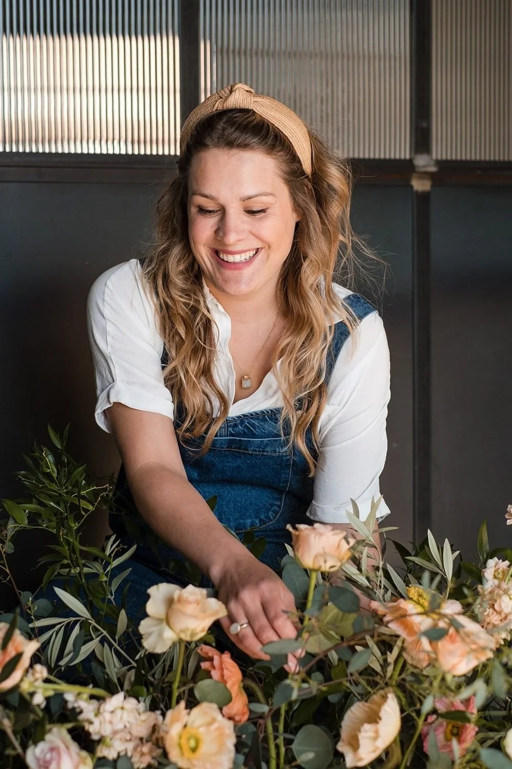 Alex arranging peach flowers in her studio