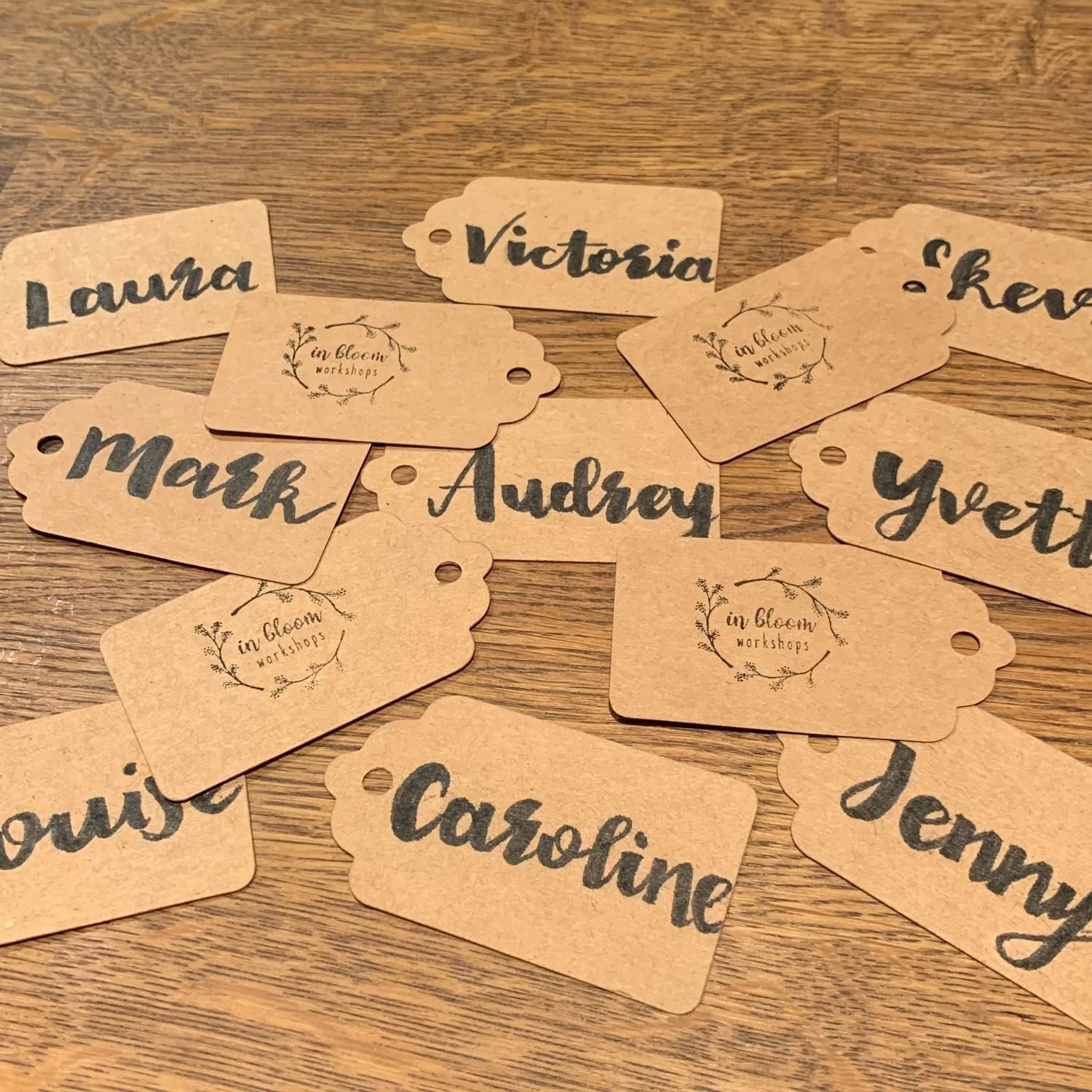 Handwritten brown name tags with guests&rsquo; names in calligraphy