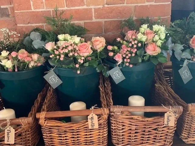 Wicker hampers filled with flowers and foliage, one for each guest