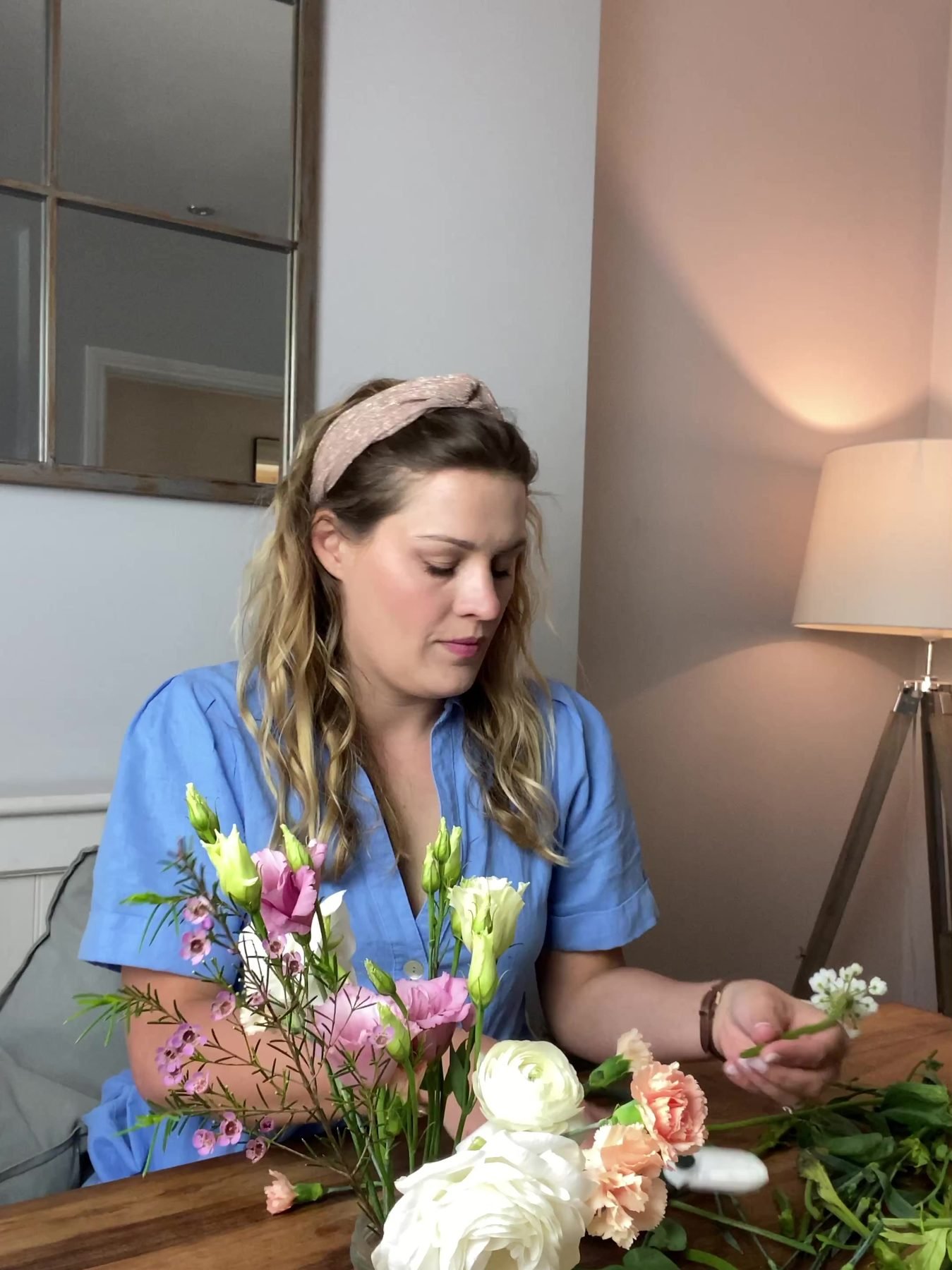 Alex arranging white roses and lisianthus in a glass jar