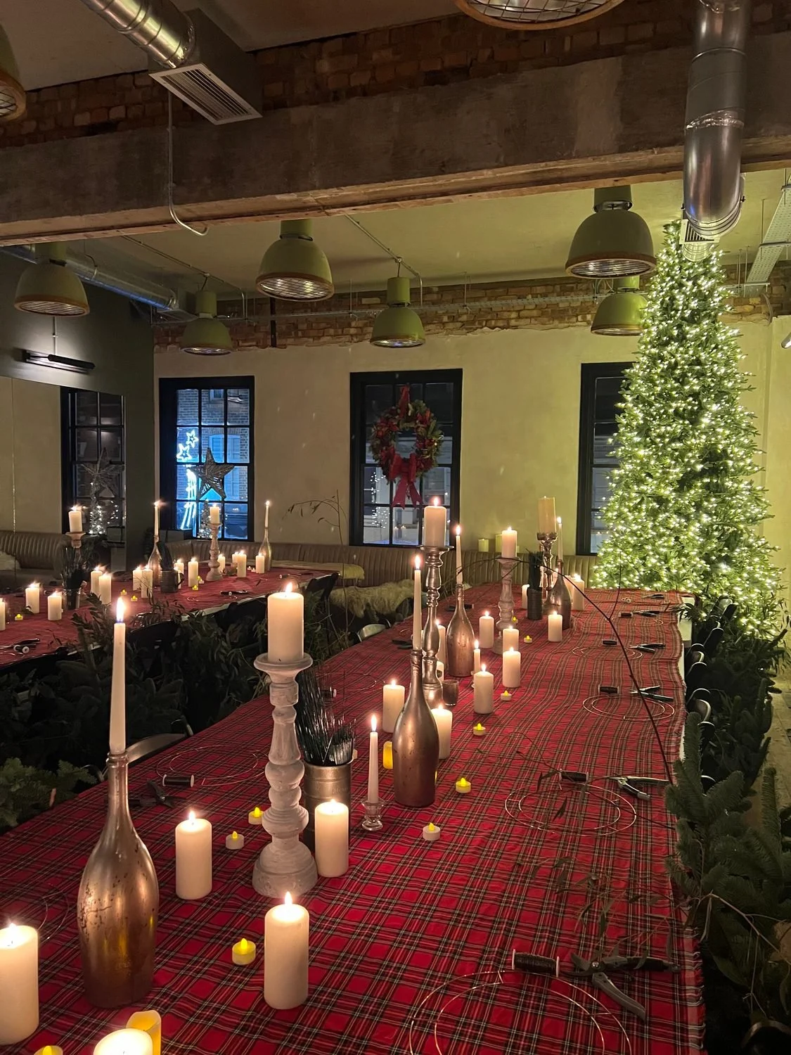 Long tables dressed with tartan cloths and candles before a workshop