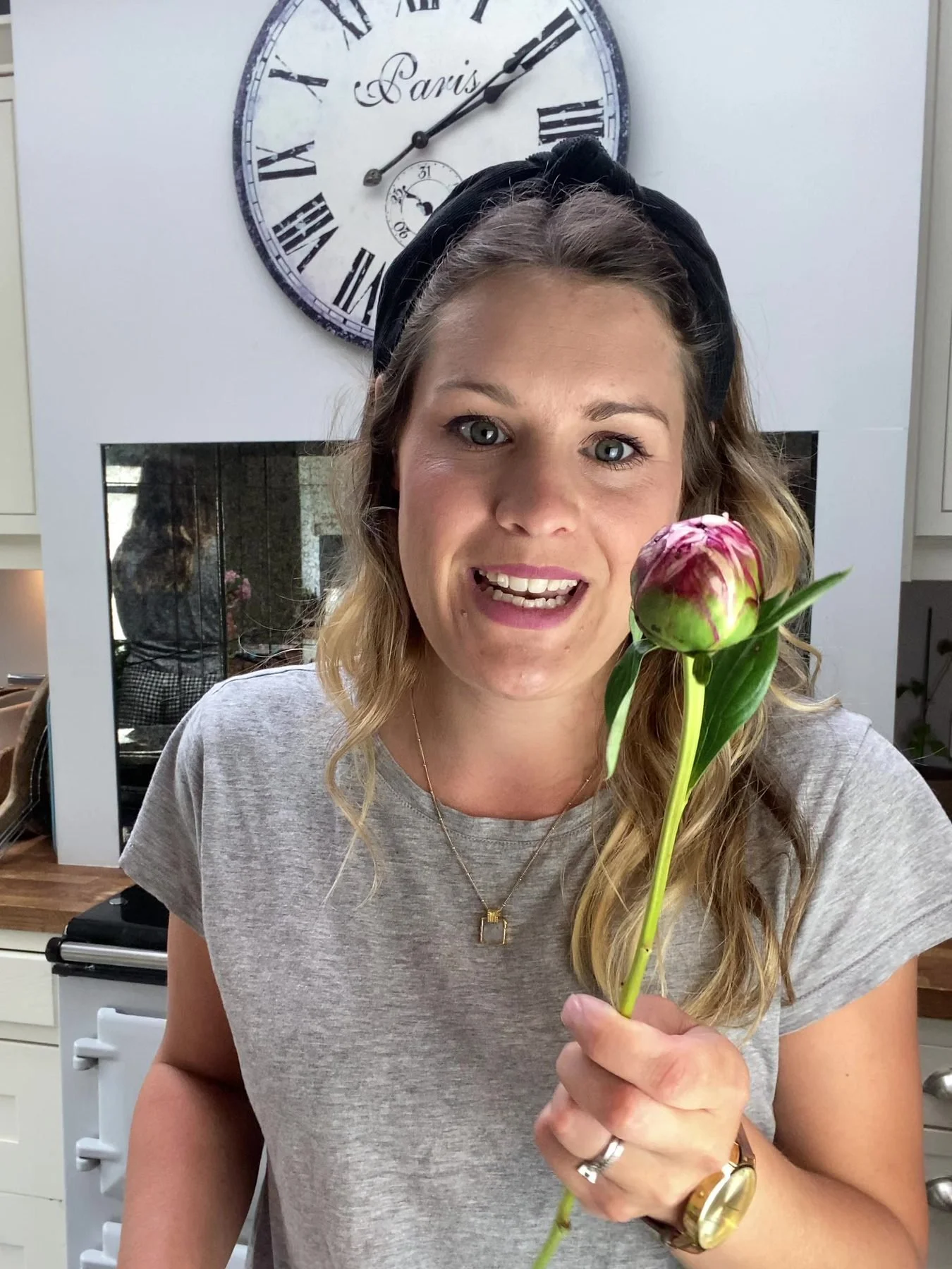 Alex holding pink peonies during a lesson