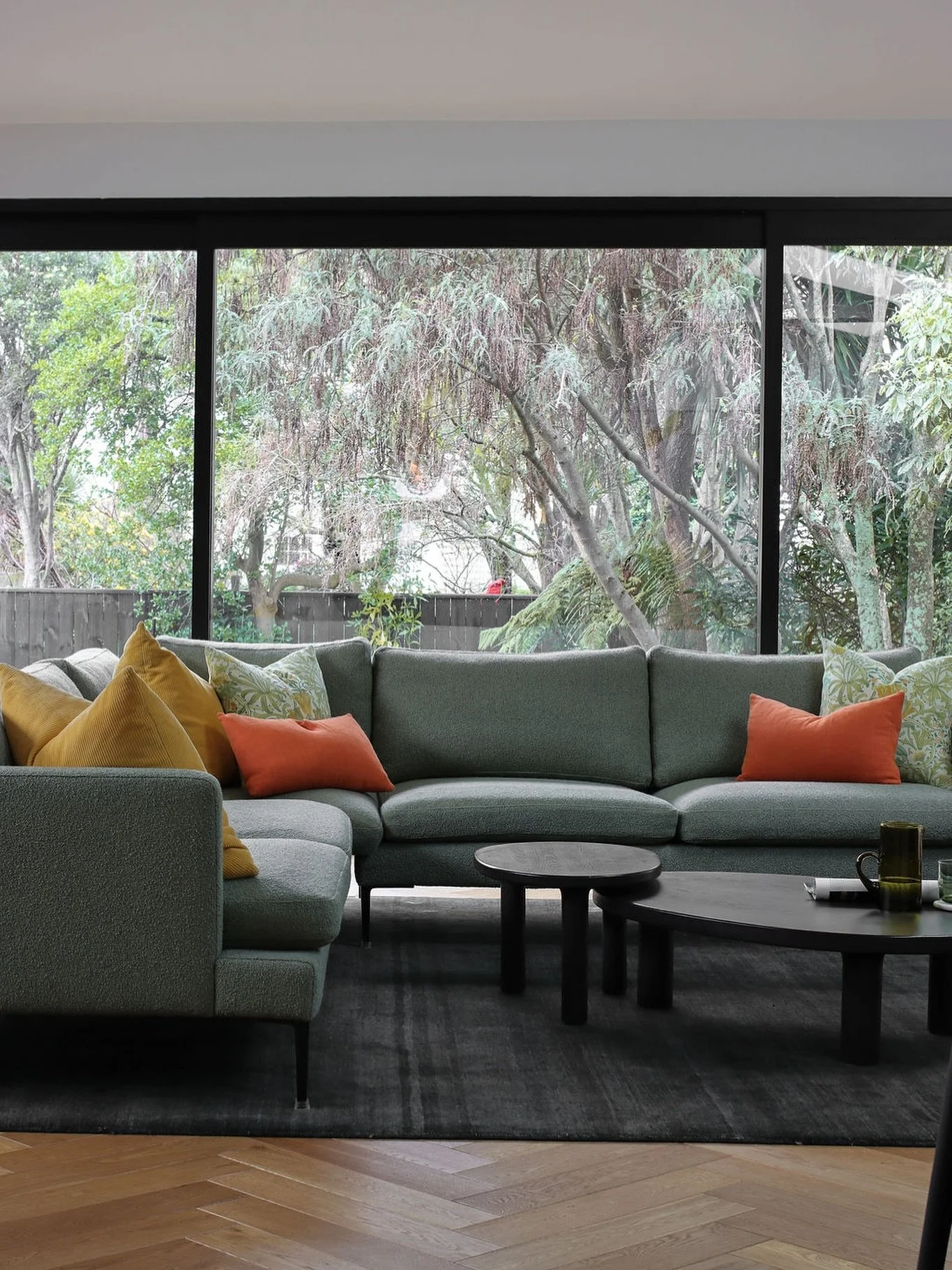 This living area, with large soothing views of the garden beyond, is rich in materiality, understated luxury, and elements of colour. Everything in this frame was selected by CMID to introduce a sense of coziness to the large open space. 
Pieces fro