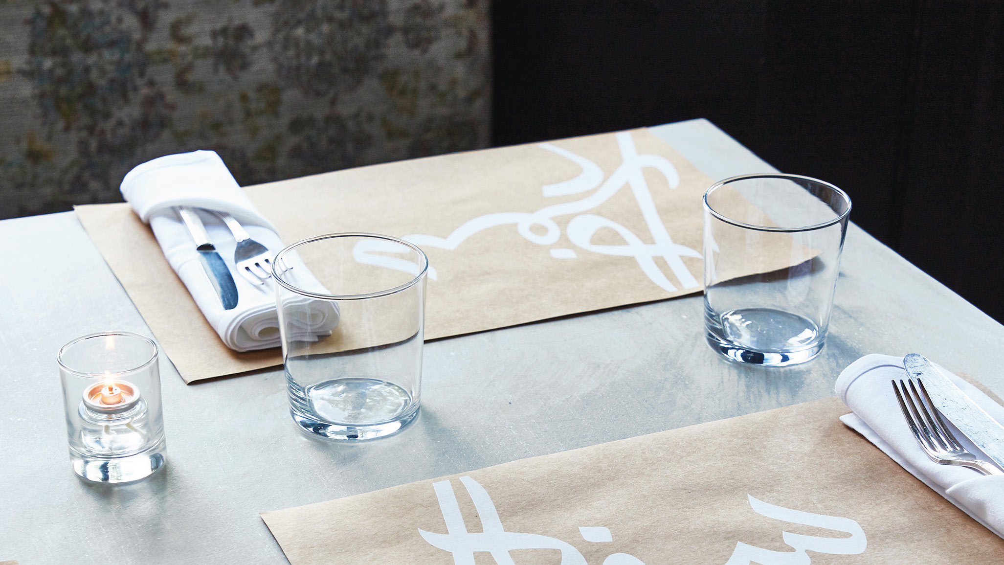 A table setting with placemats, silverware and a menu