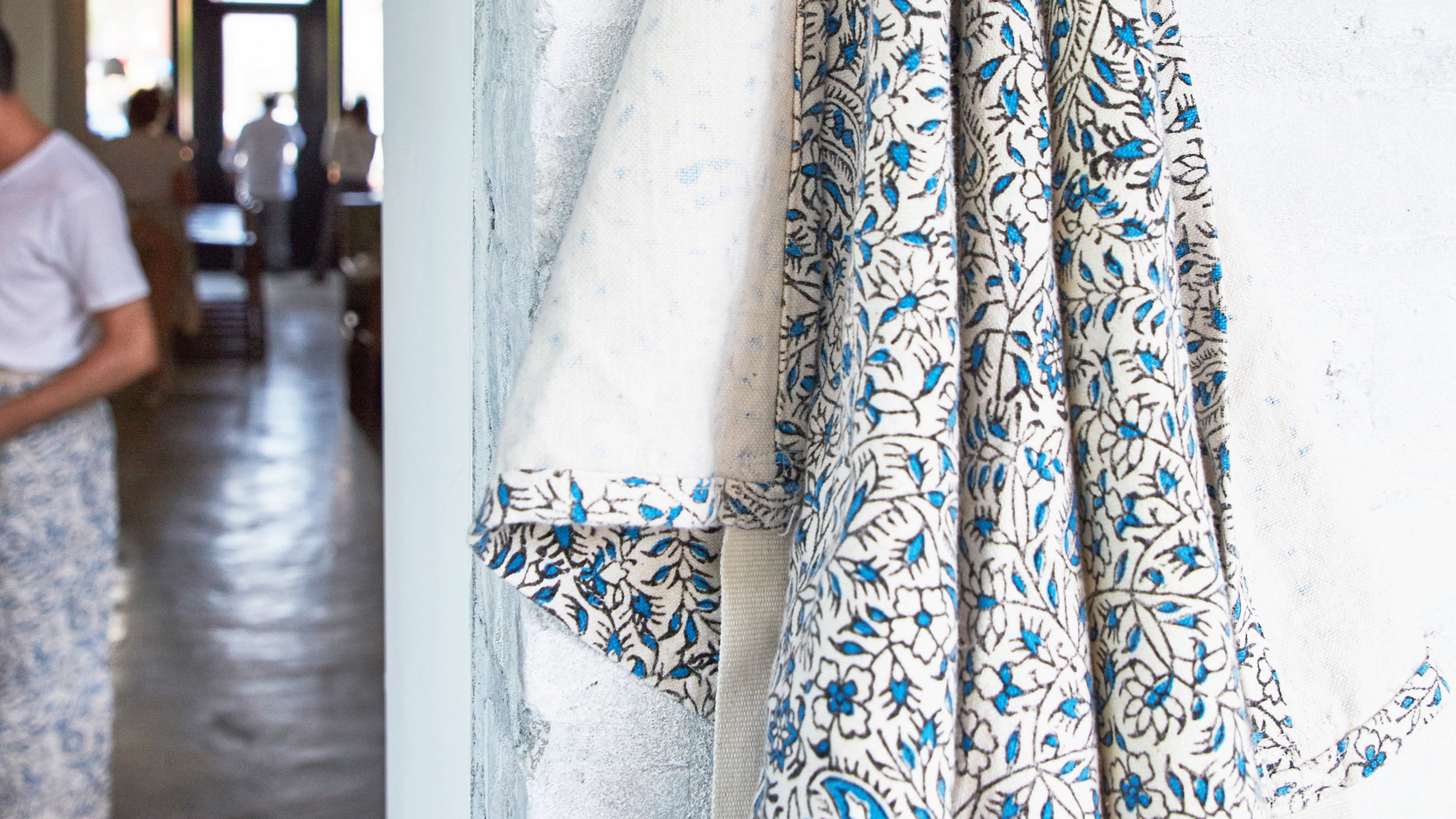 Partial view of dining room with a blue and white apron used by serversapron