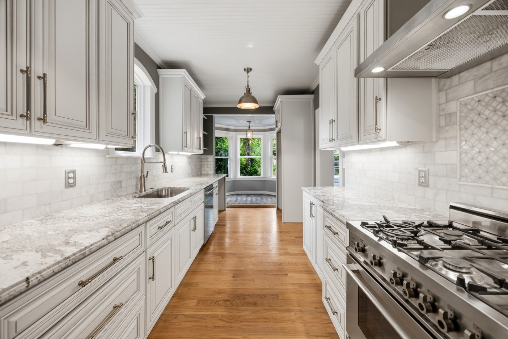 Floor-to-ceiling custom cabinetry lines this bright galley kitchen.