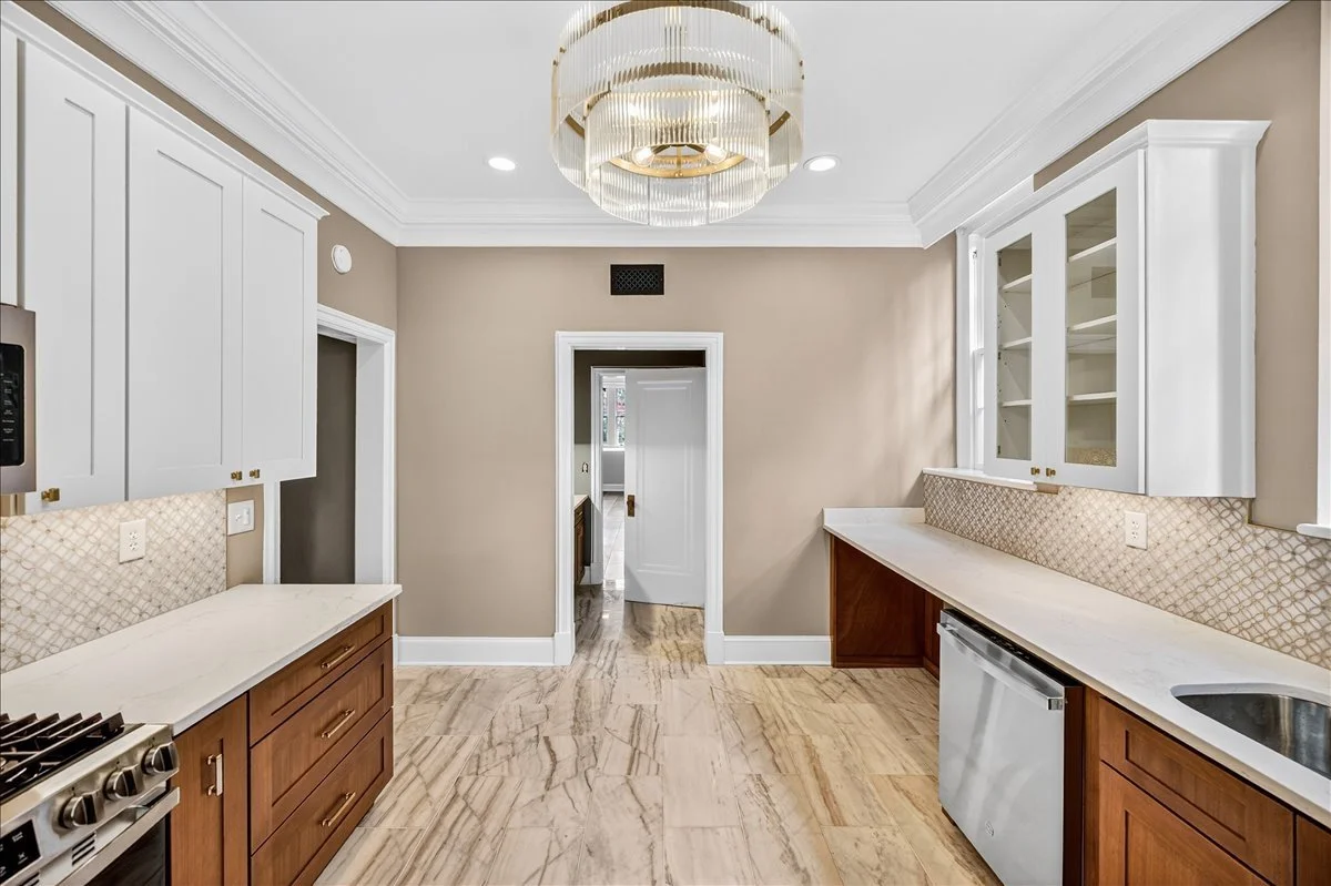 Custom white and wood-tone cabinetry finished with glass-front display doors.