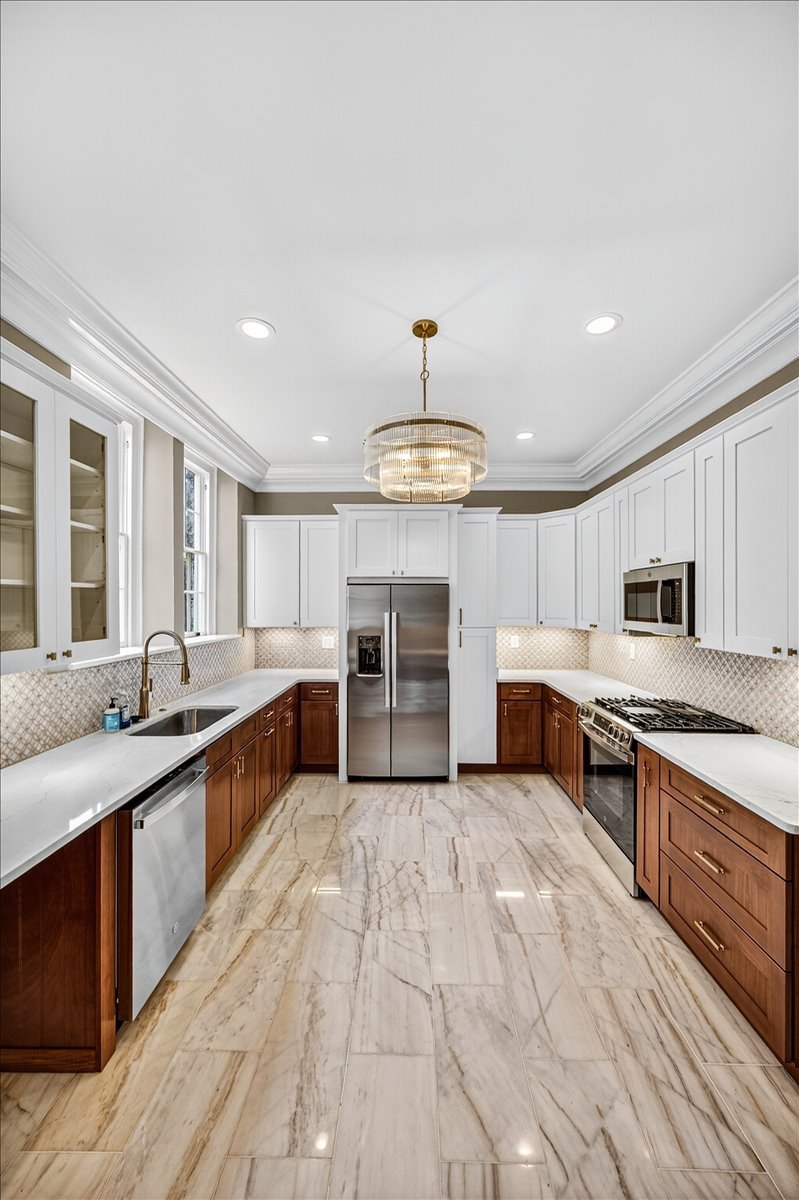 Custom two-tone cabinetry built around a paneled refrigerator surround.