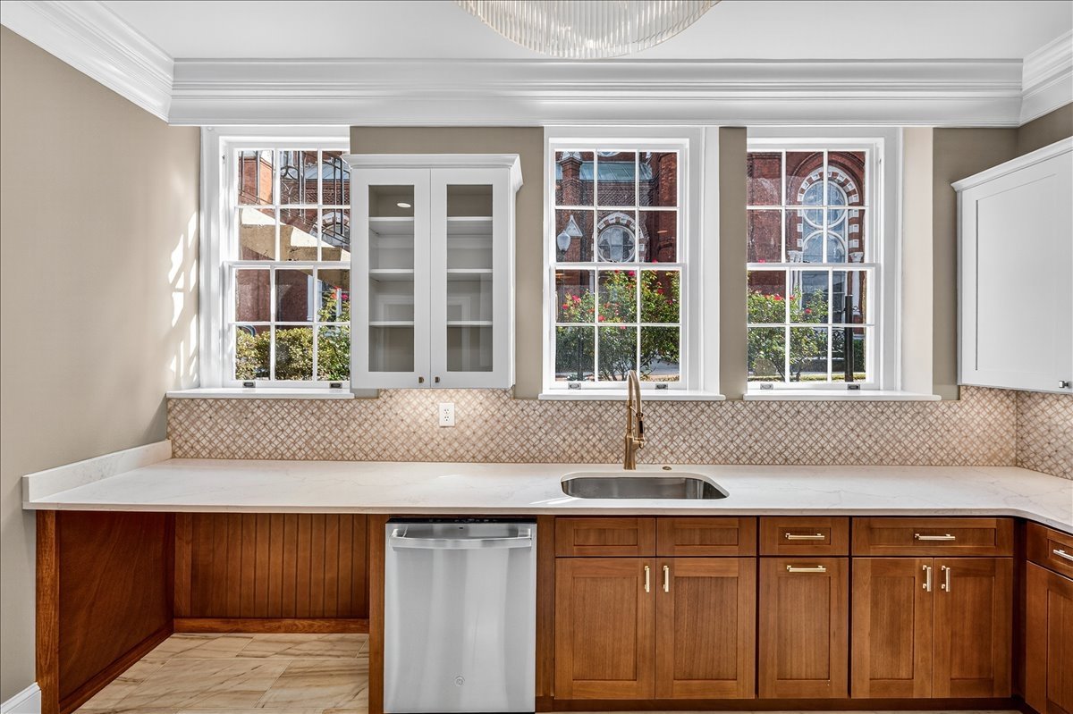 Custom cabinetry and quartz countertops framed by tall windows.