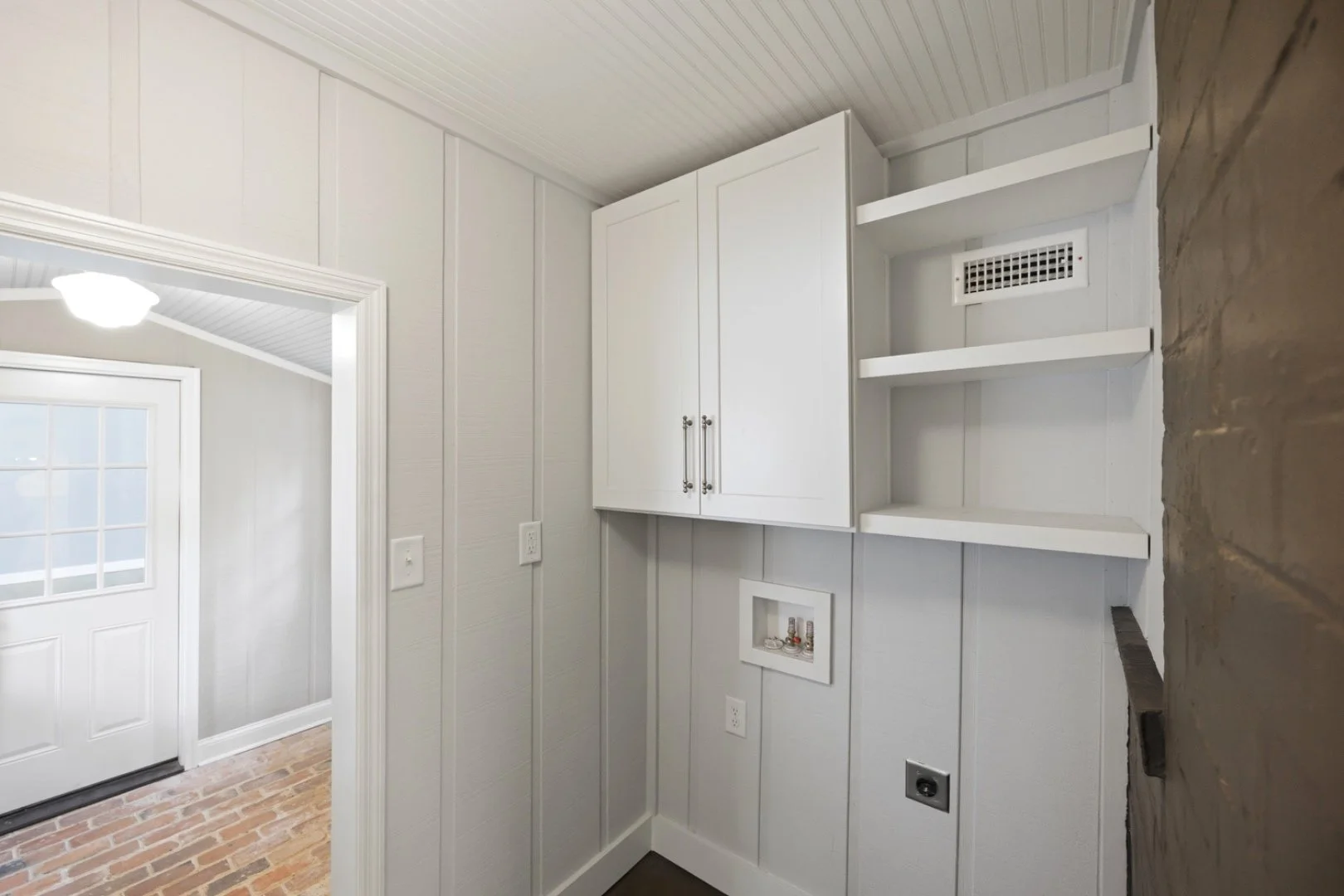 Built-in mudroom cabinetry and open shelving, custom-fit into every inch of the space.