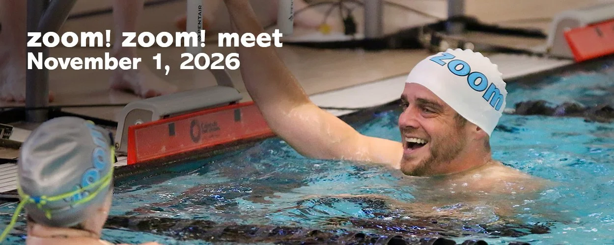 An image that shows two zoom team members laughing together after their race at the 2025 zoom zoom meet held at Kalamazoo College Natatorium in November 2025