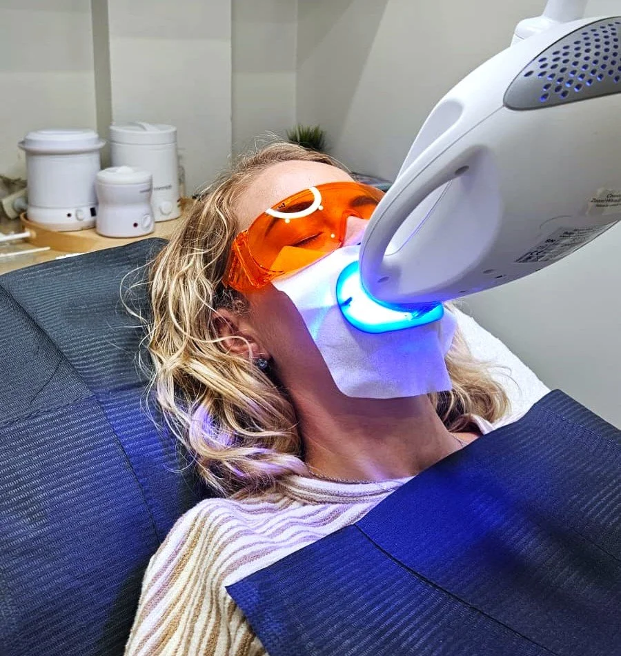 Professional in-chair teeth whitening treatment performed under dentist supervision.