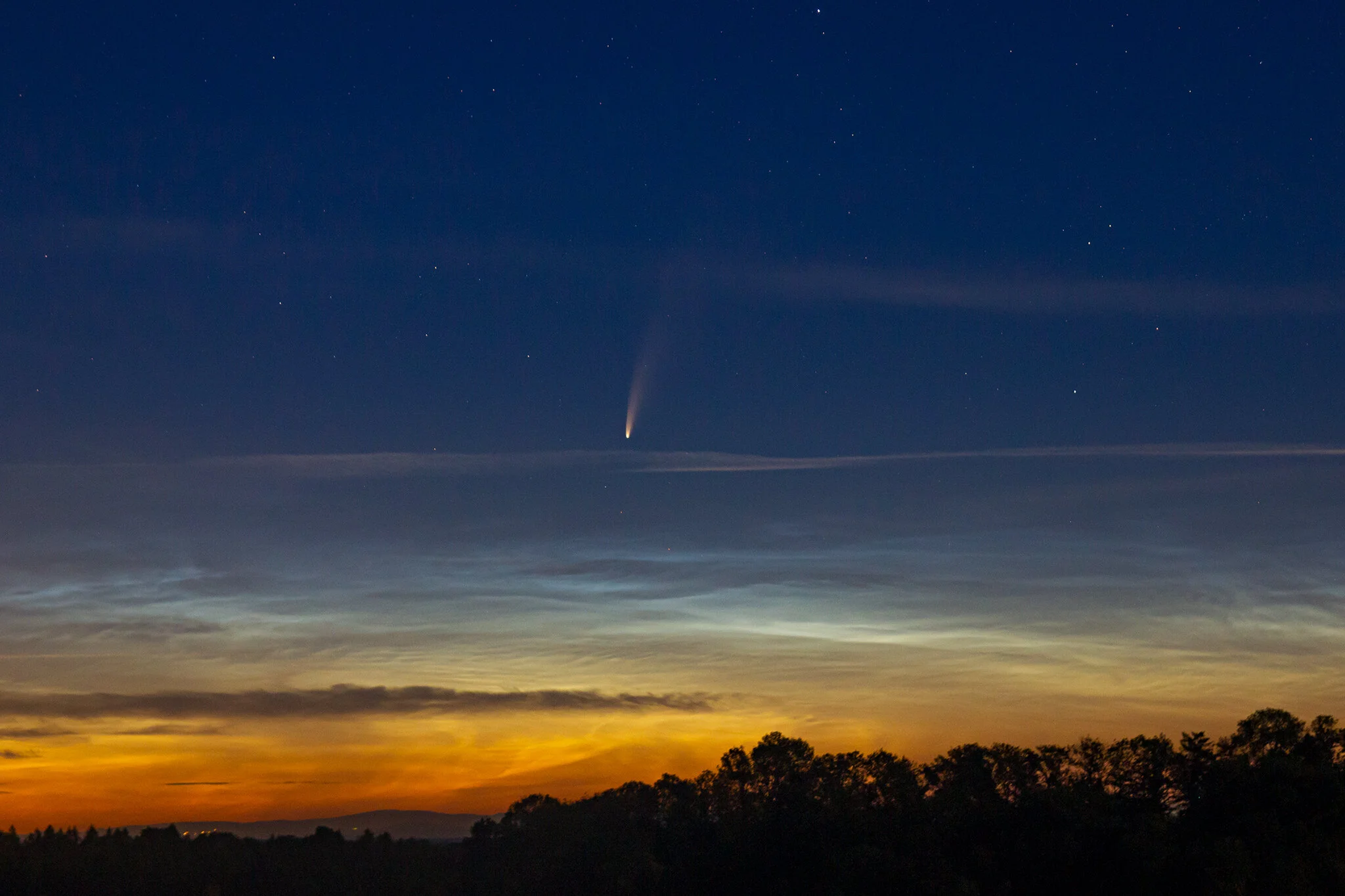 Comet C/2020 F3 (NEOWISE), rising above some noctilucent cloudsImage by H. Raab
