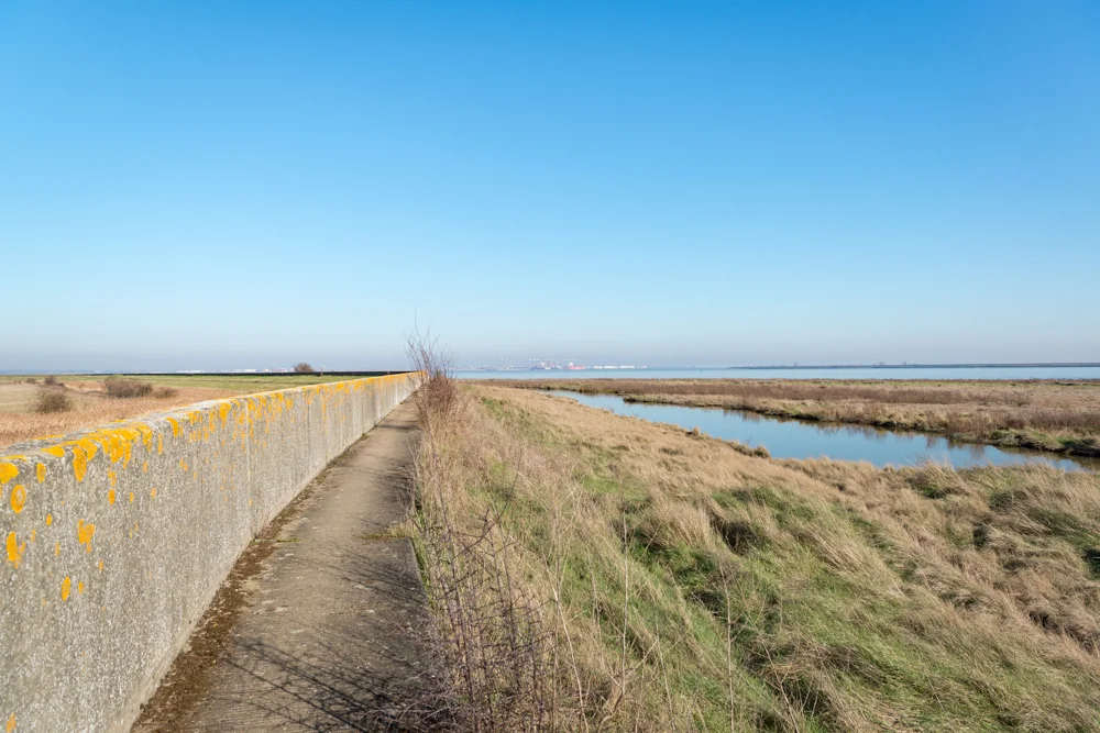 Walking along the sea wall by the Thames estuary at East Tilbury