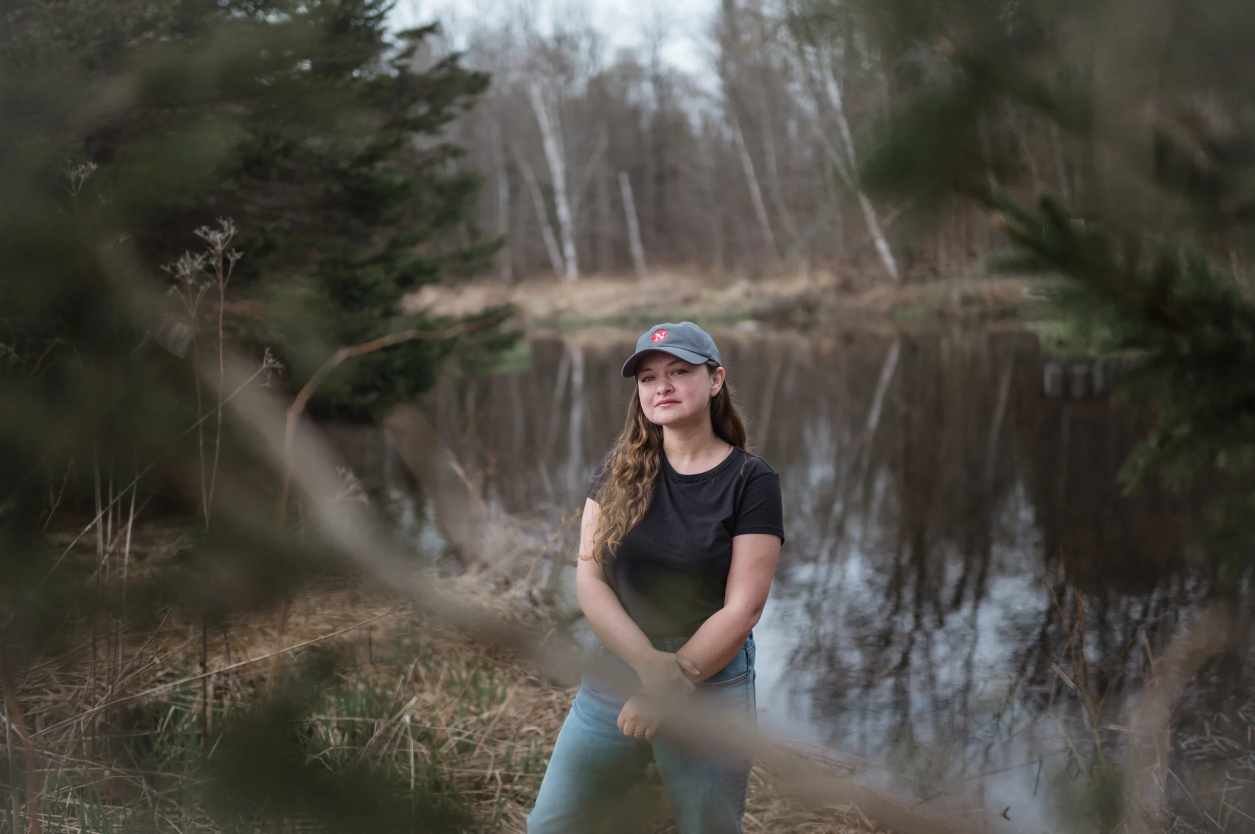 Leah Borts-Kuperman stands near a creek and trees in Northern Ontario, Canada.