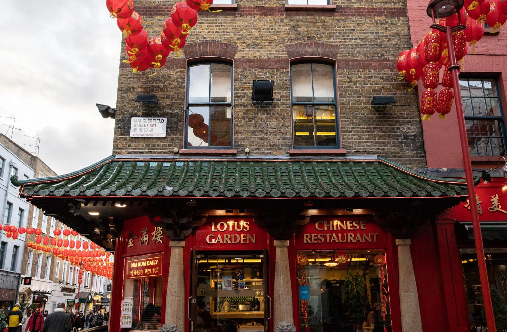 In Chinatown in London, fresh red lanterns are hung from the buildings to celebrate the Chinese New Year and the Year of the Tiger. This restaurant on the corner of Macclesfield Street is the Lotus Garden. This building is in a typical style for Chin