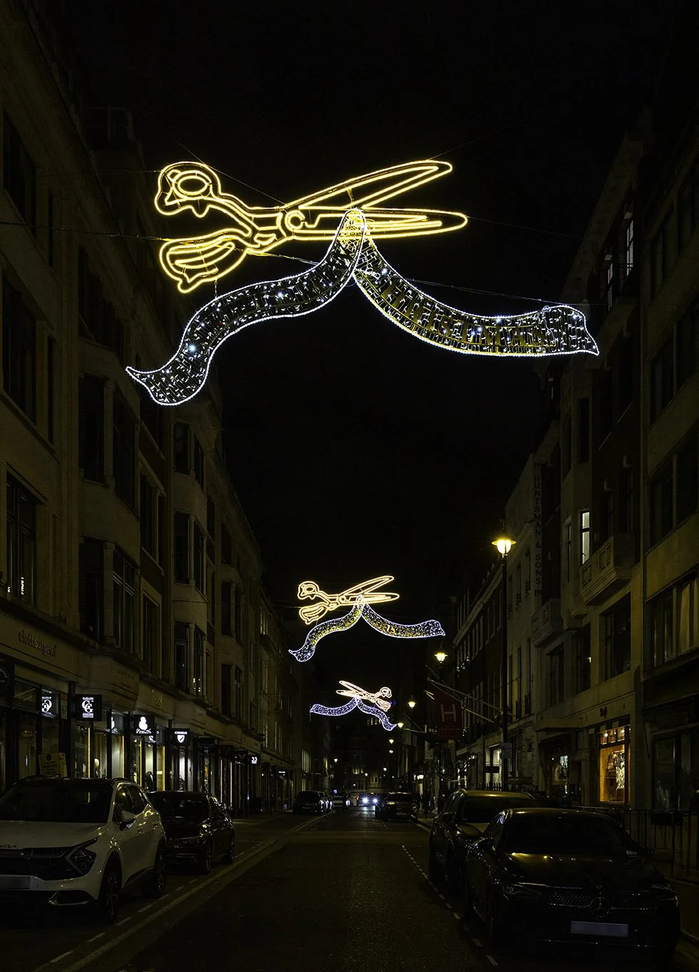 Savile Row Christmas lights 2025. Golden scissors cutting silver ribbons.