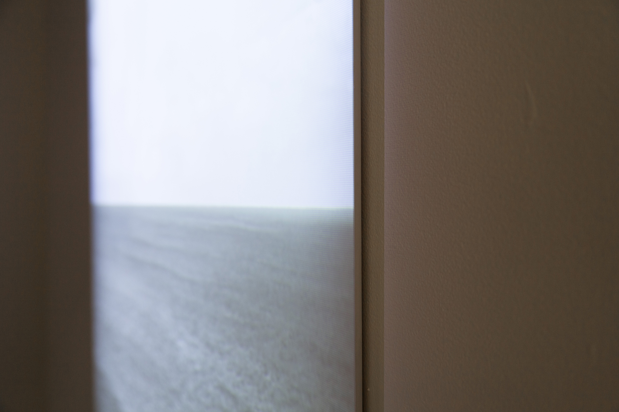 detail of Horizon, video projection on beveled wood panel, 4 minute loop. Video depicts an ocean horizon that slowly gets erased by fast moving storm clouds, leaving only a view of a gray monochrome sky. 2013. collaboration with Carlos Vela Prado