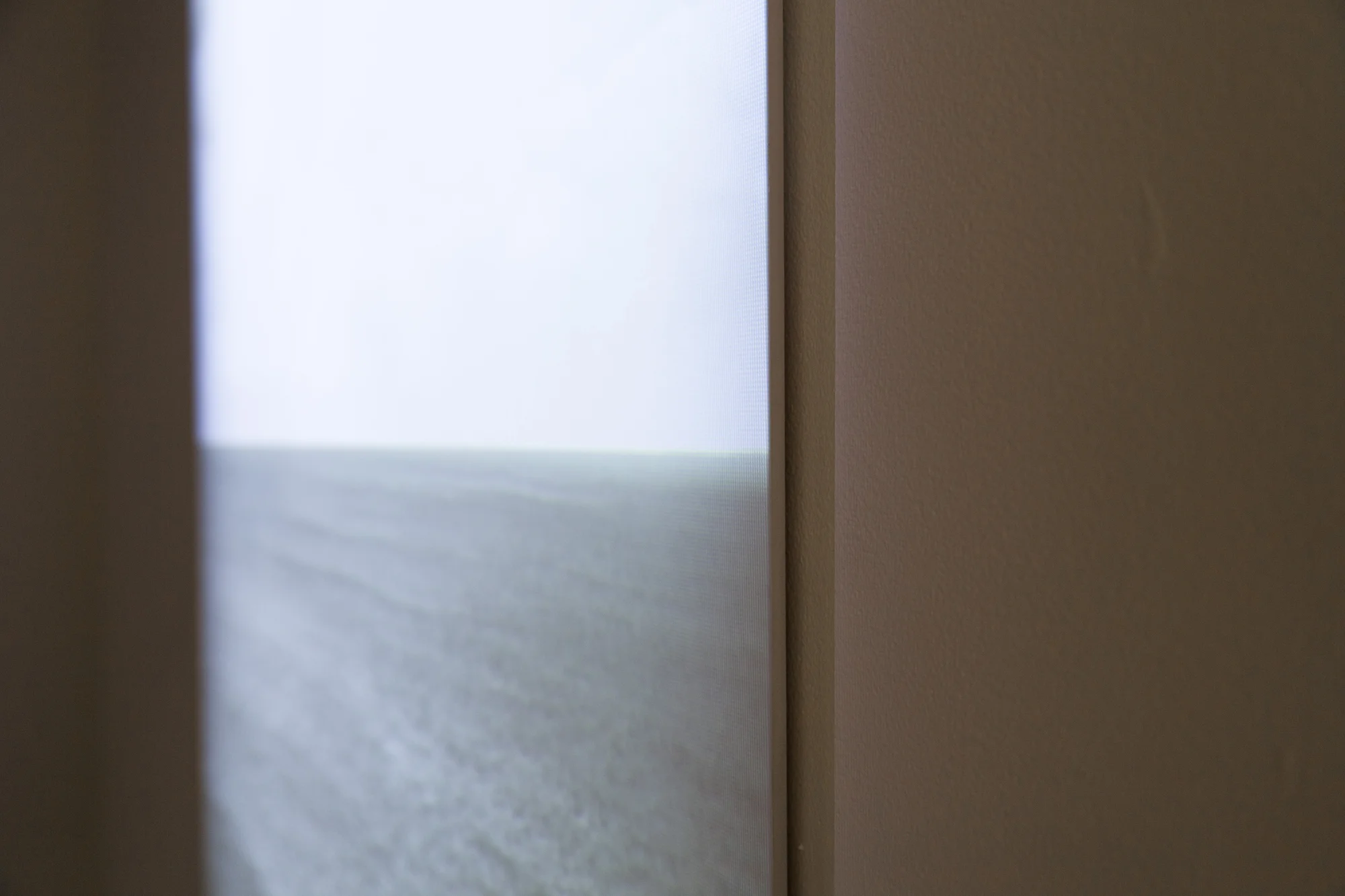 detail of Horizon, video projection on beveled wood panel, 4 minute loop. Video depicts an ocean horizon that slowly gets erased by fast moving storm clouds, leaving only a view of a gray monochrome sky. 2013. collaboration with Carlos Vela Prado