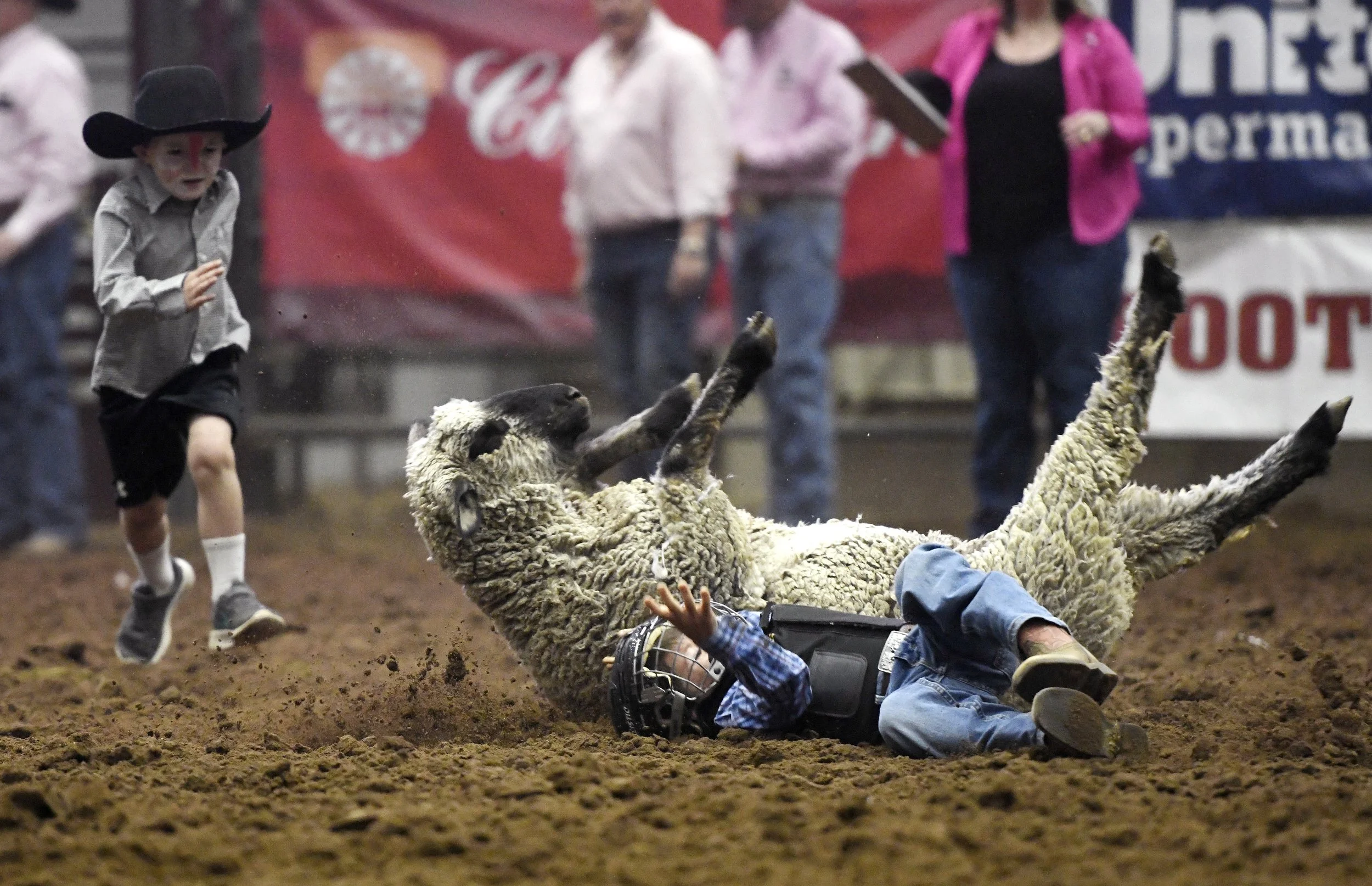  Five-year-old Brice Scott, left, runs to assist Liam Latiner during mutton busting at ABC Pro Rodeo, Thursday, March 31, 2022, in Levelland, Texas. Latiner was OK after the fall. 
