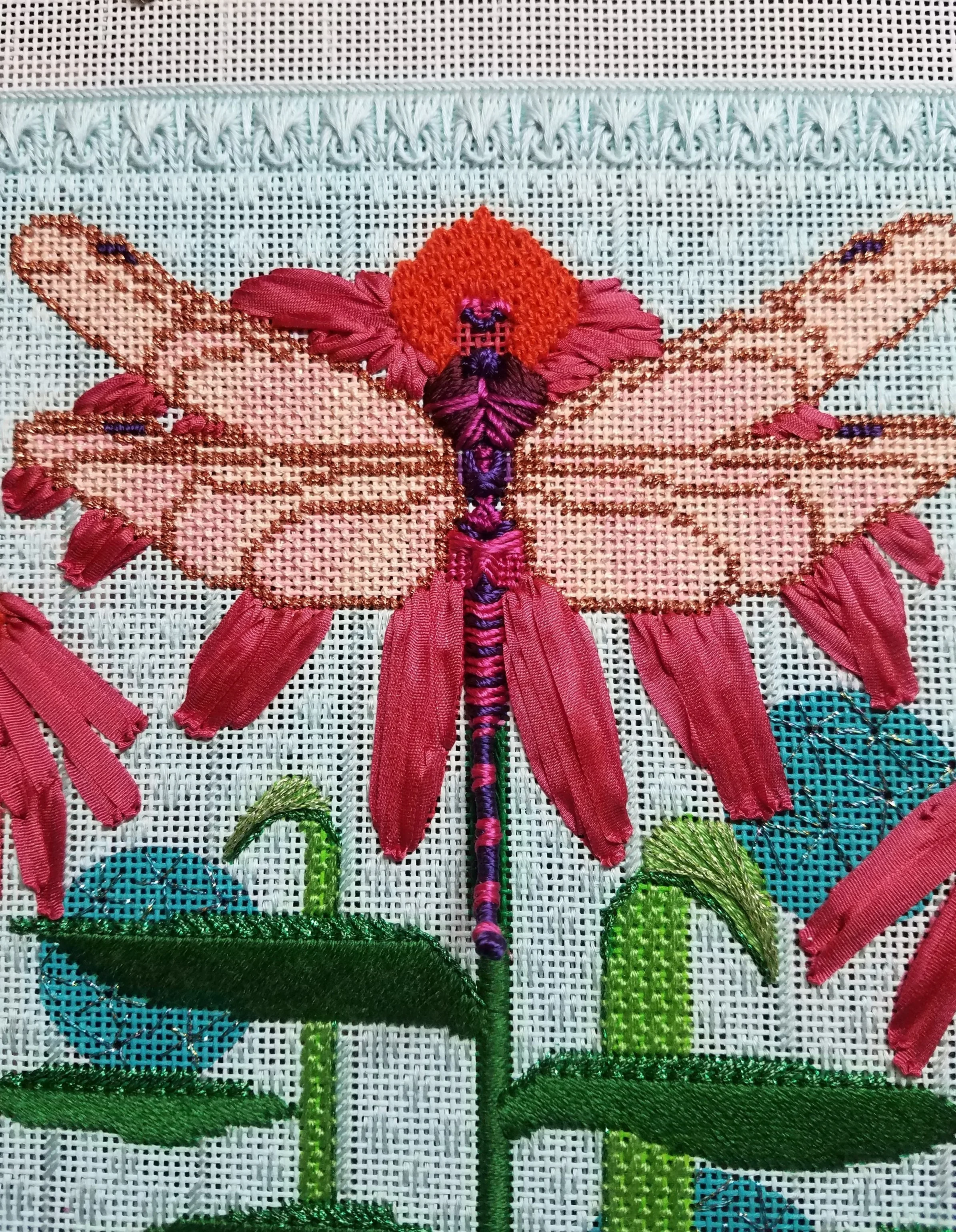 Wings on canvas, large pink flower and bug body complete. Tail of dragonfly does come off the canvas. Note the big space for the eyes…ugh