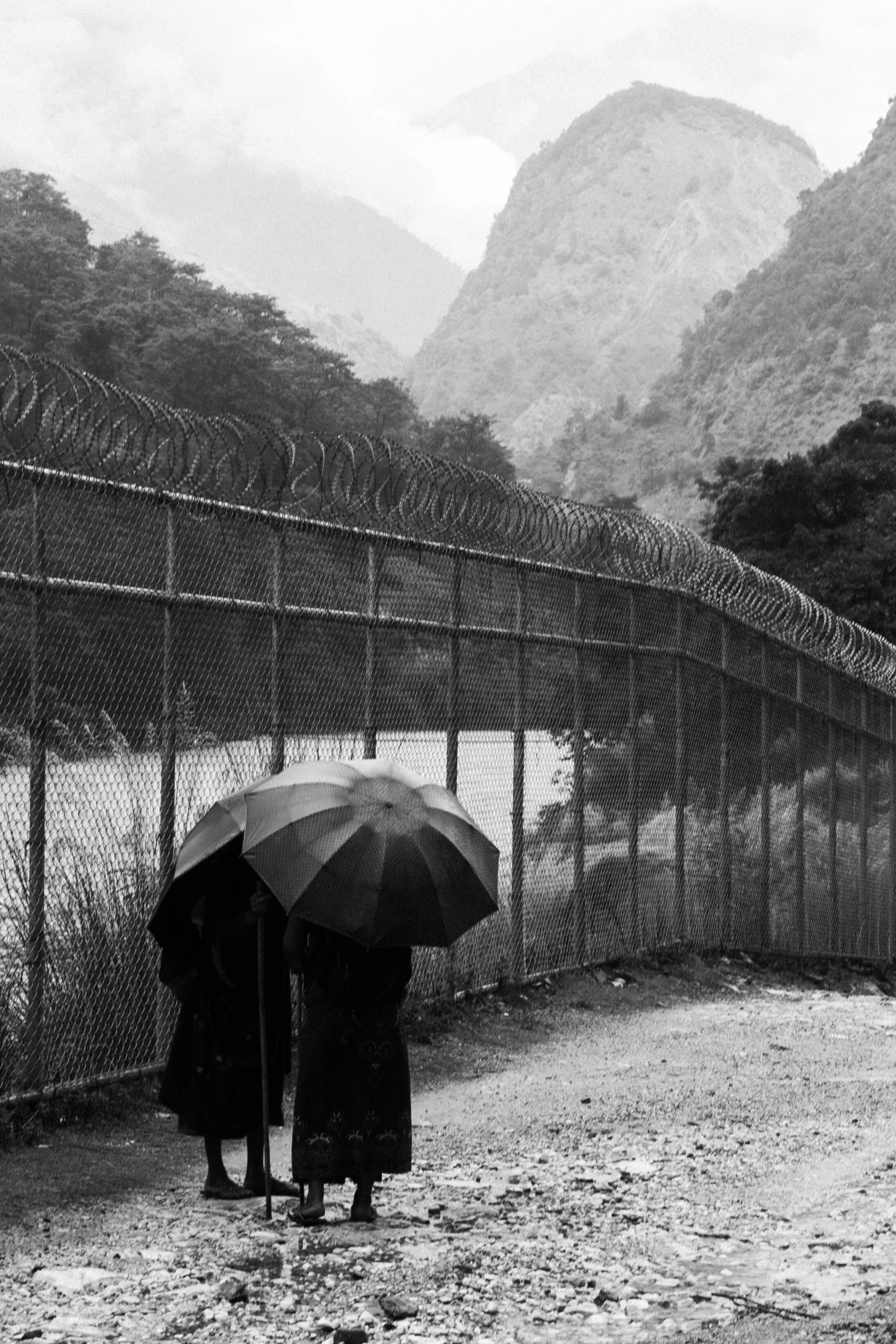 Women with Umbrellas standing in the rain, talking, maybe about the deadly landslides that went on in the days before taking this picture.