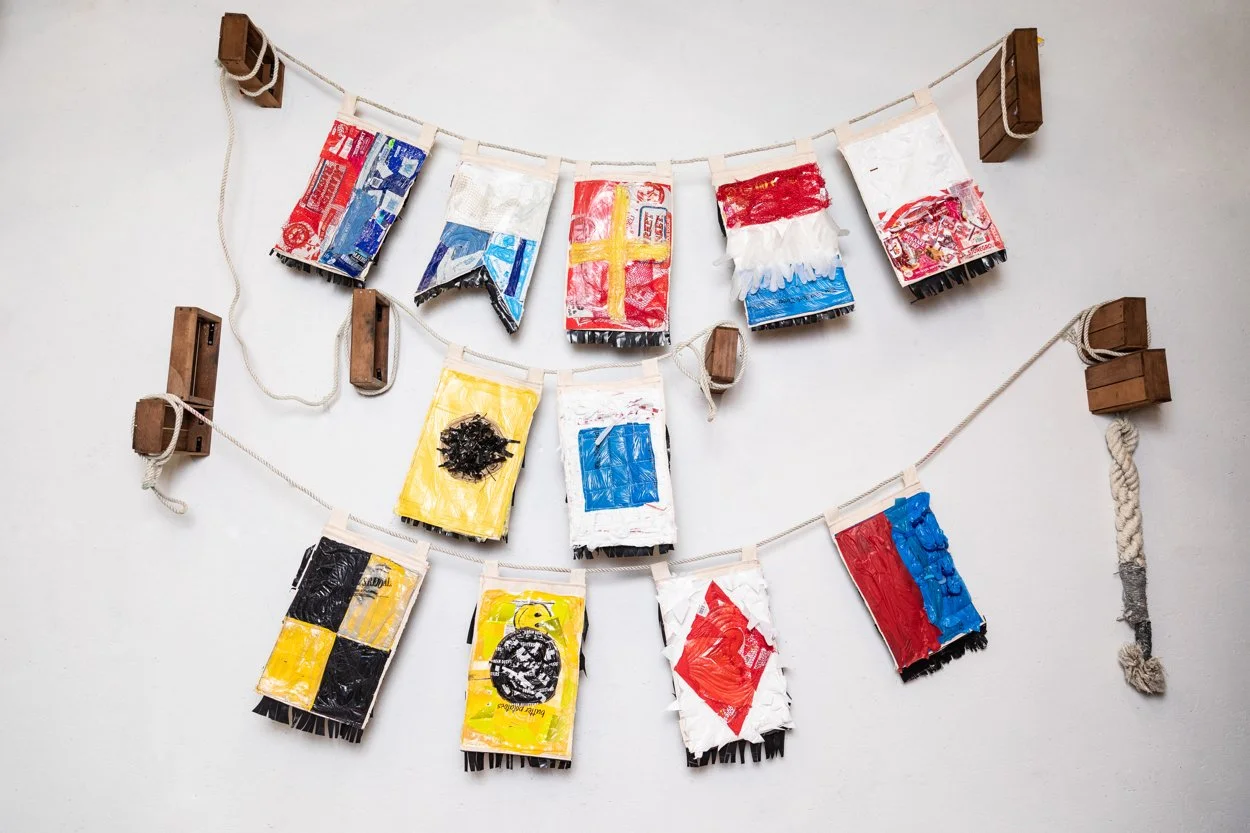 "Altering Course", single use plastics and found objects and thread.  
Click on this photo to see a short video of each individual flag.