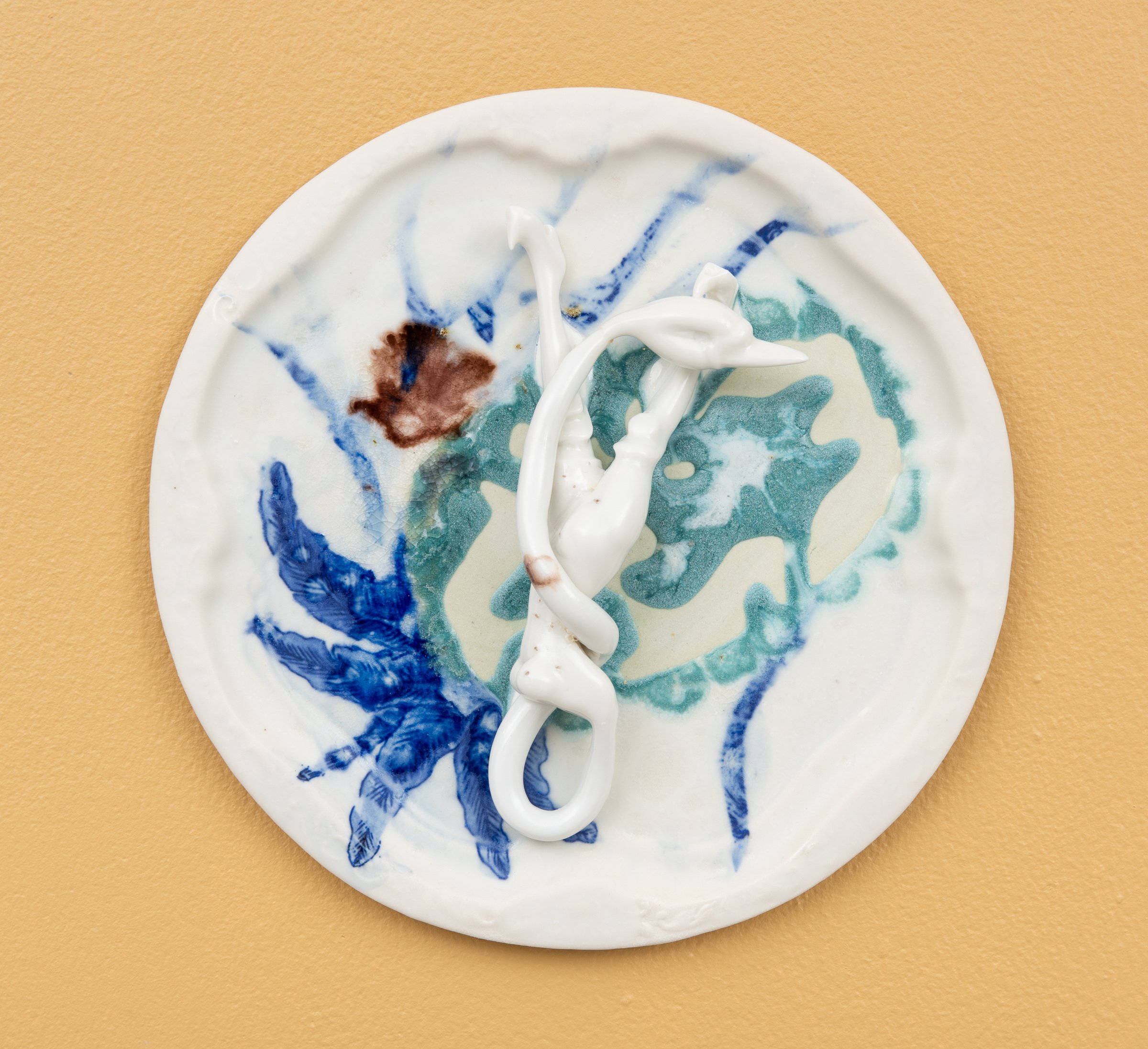  Why do Europeans put plates on their walls? VII | 2022  Porcelain, glazes, porcelain decals and tissue paper, press molding. 27x27x4  Photo: Thomas Tveter 