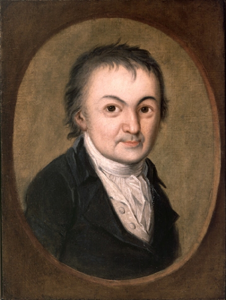 Image Description: oil painting of man in period clothing with tight collar. He is facing the viewer, with pursed lips and bright affect. He has straight, unkempt hair. He is wearing white shirt with collar and black jacket. The painting is framed as a photo, with oval brown frame.