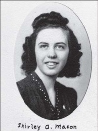 Image Description: this is a school yearbook type black and white photo in oval frame of a young woman with dark hair curled on top and on each side of her face. She has a bright expression, and is wearing a dark dress that has some decoration around the collar. There is handwritten lettering beneath the photo that says “Shirley Mason”.