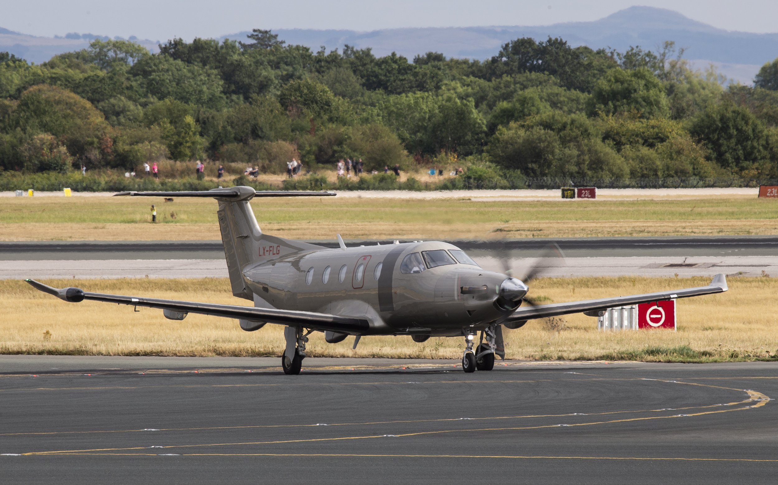 16th August 2026 - Jetfly On-Demand Pilatus PC-12 LX-FLG positioning in from Leeds Bradford.  The aircraft later departed to Braunschweig which is a small airport to the east of Hannover.  Note all of the spotters, photographers and public on the sou