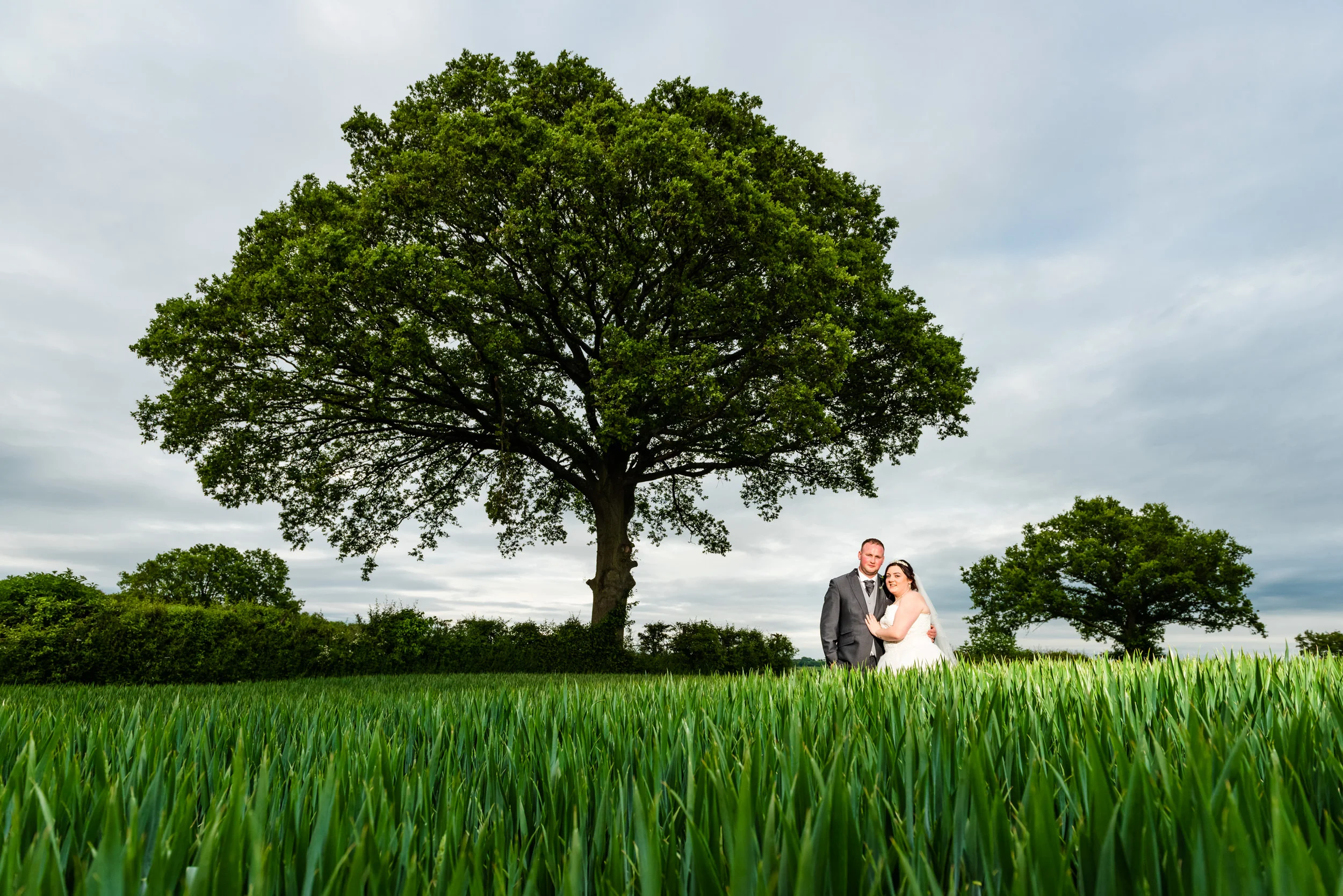 Bride and Groom posing in the green fields of Manor Hill House