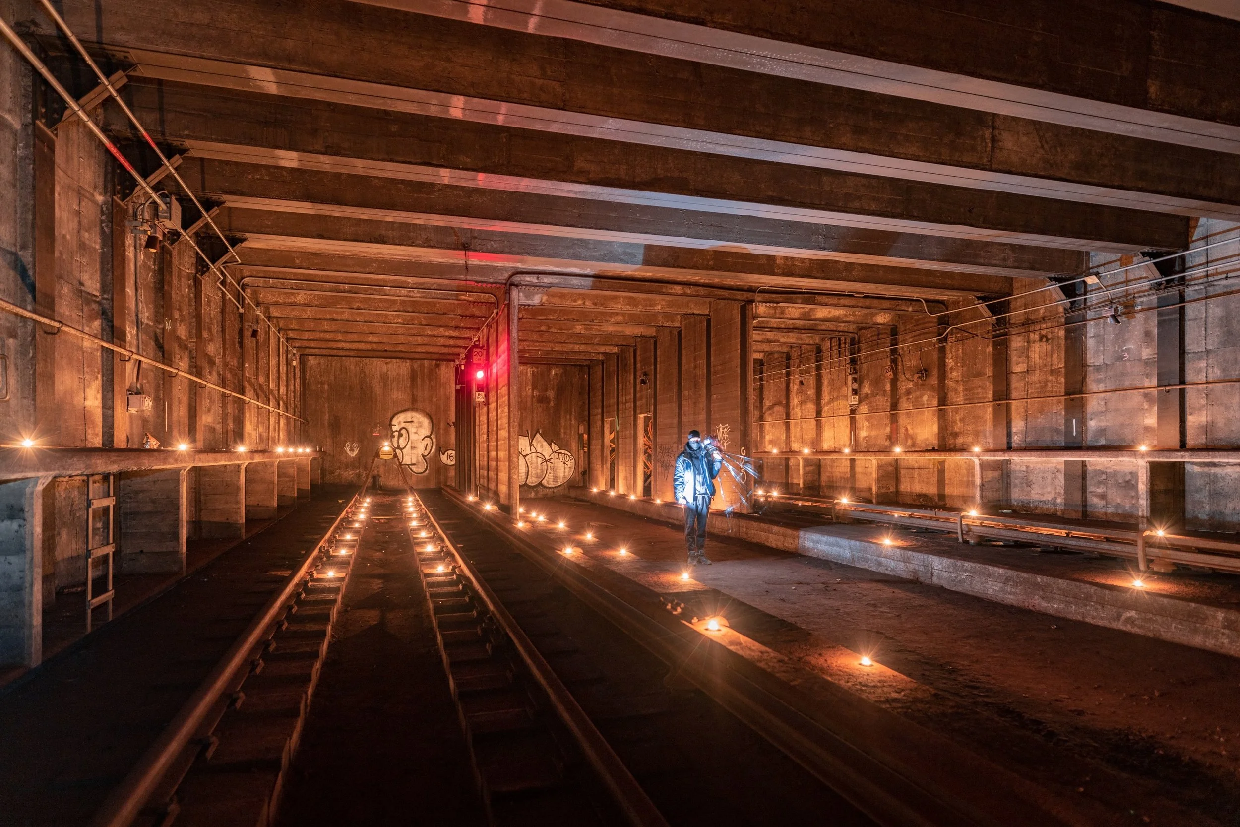 View of the end of the tail tracks, including the still-lit signal, bumpers, old tracks, candles, and a friend.