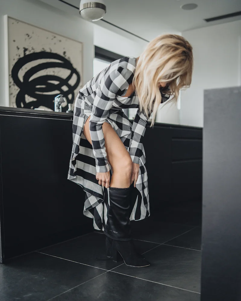 Monika Dixon of Monika Dixon Public Relations is wearing a Monse checkered dress and over-the-knee boots Stuart Weitzman Boots.