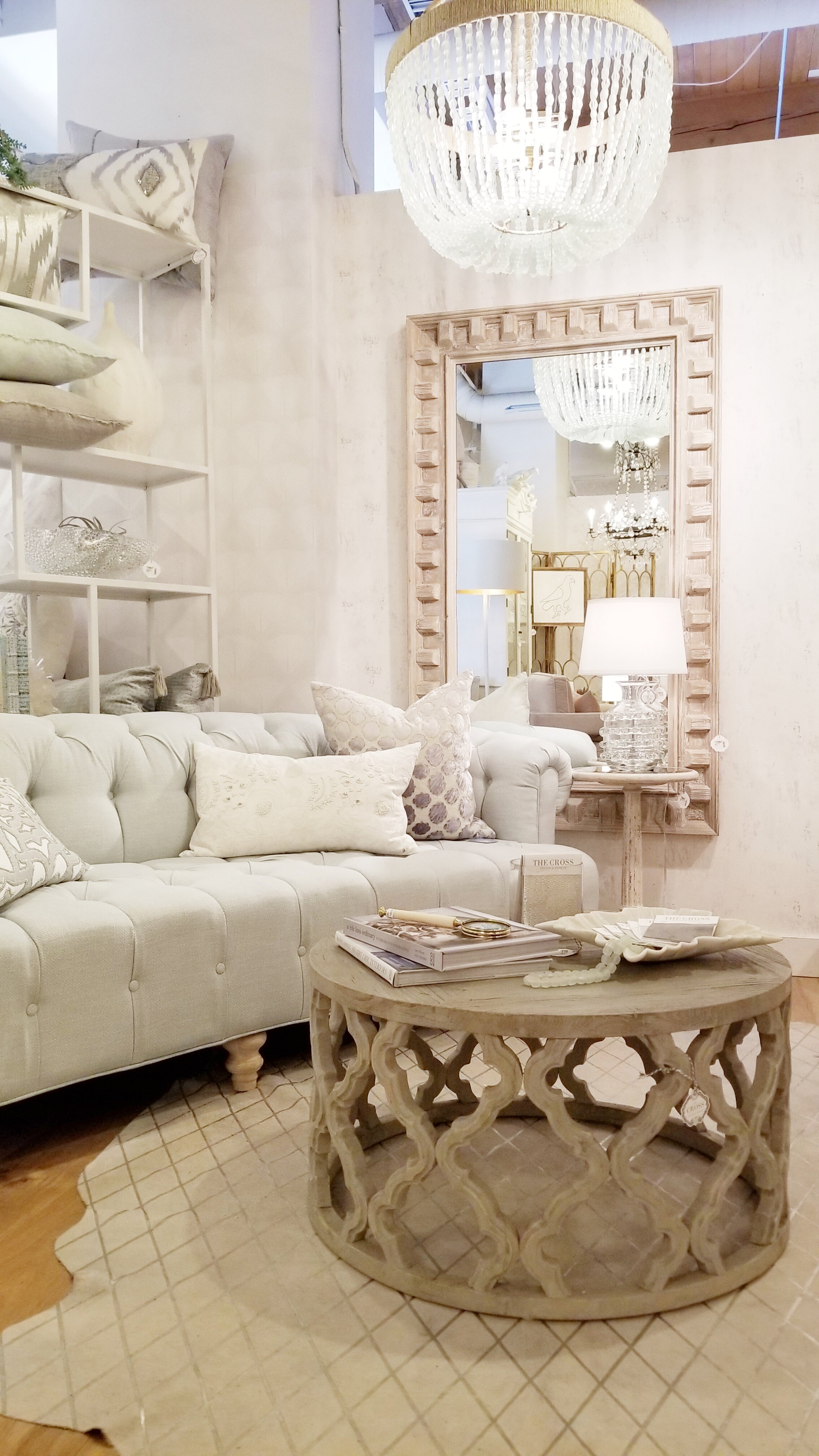 interior-designs-by-adrienne-cranbrook-bc-button-tufted-sofa-mirror-with-wood-frame-beaded-chandelier-the-cross-decor-&amp;-design