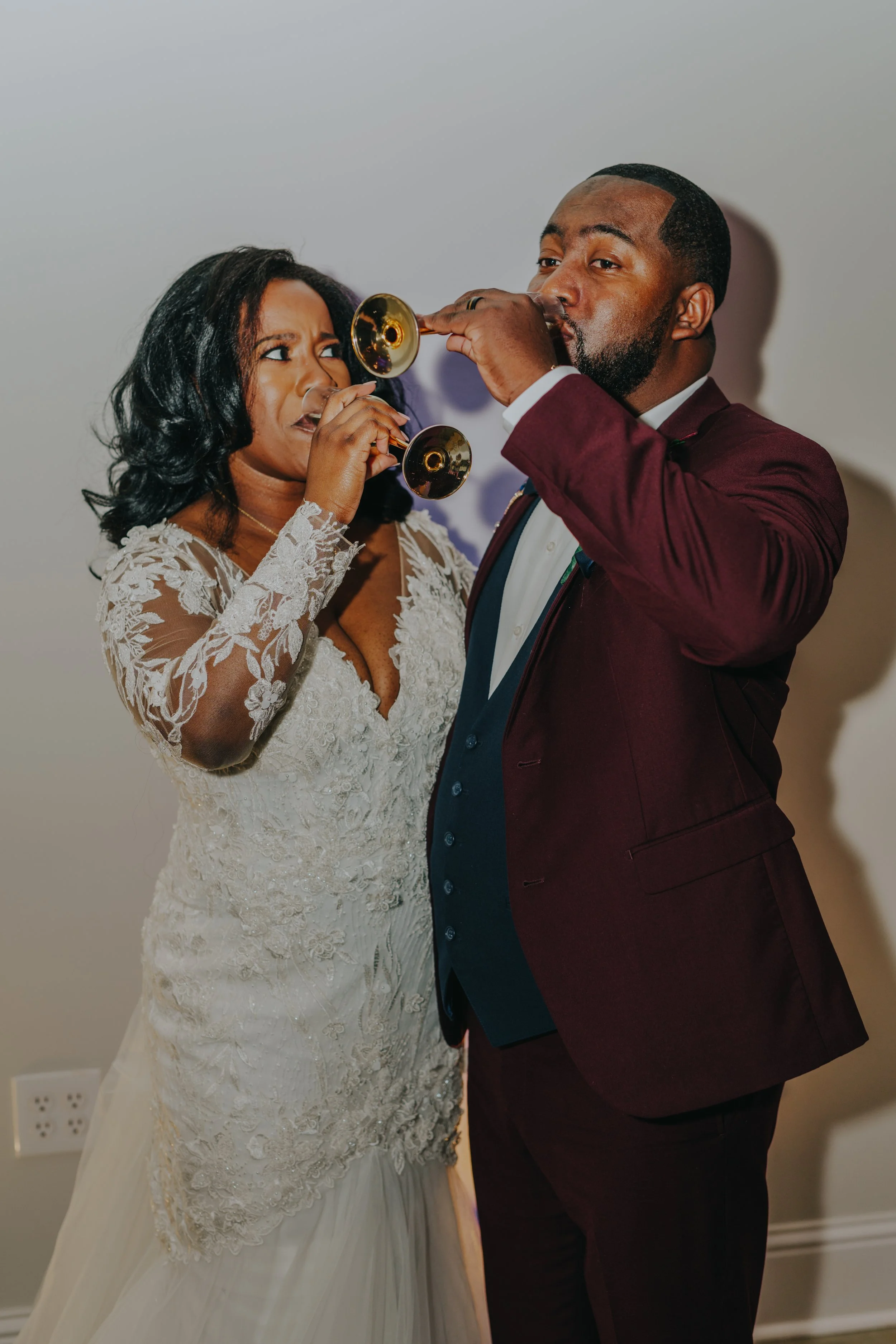 A bride and groom playing trumpets at their wedding reception.