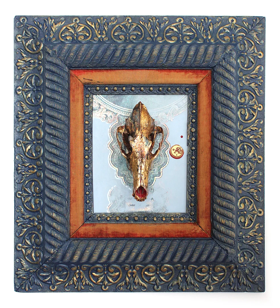 Title: Elicit This is the latest piece in the series of a new direction that Anthony is artistically heading. He is working on a unique fusion of painting, drawing and re-purposed objects. This piece features an authentic coyote skull that has been hand painted and gold leafed, mounted on a hand painted acrylic/mixed media background, and framed in a hand painted antique frame. The skulls that he acquires come from humane and environmentally responsible means. Adding to the flair, is the custom made wax stamp signature you will find on each painting. Each wax stamp has it's own unique design that is specific to the year the piece was created. This piece has been professionally framed and mounted with a dust cover and installed hanging hardware. 20.75"W X 22.75"H X 3.5"D SOLD